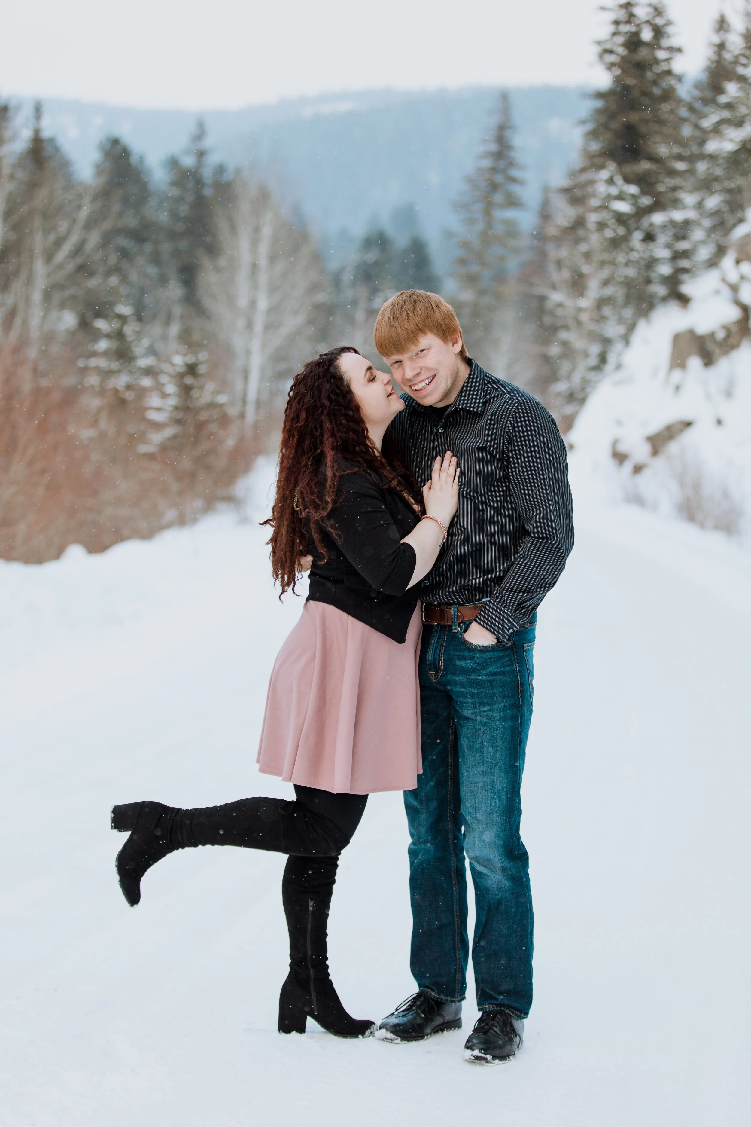 women wearing a pink skirt kissing her fiancé on the cheek at dalton lake, SD