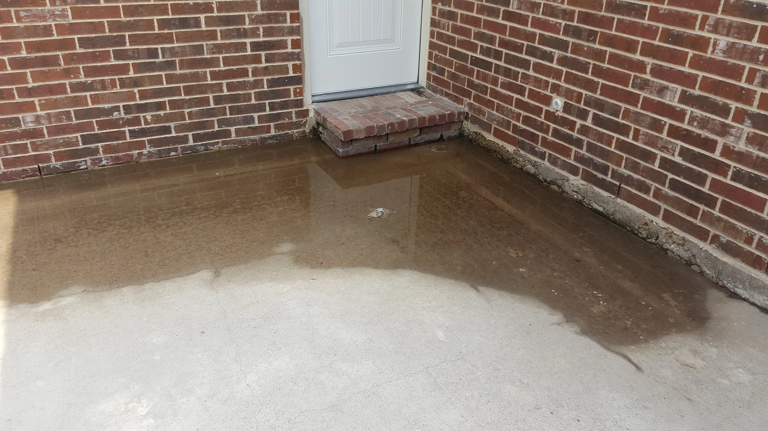 New construction inspection: the driveway was sloped towards the house. this condition can promote rain water seepage through the brick wall weep holes as water levels increase.
