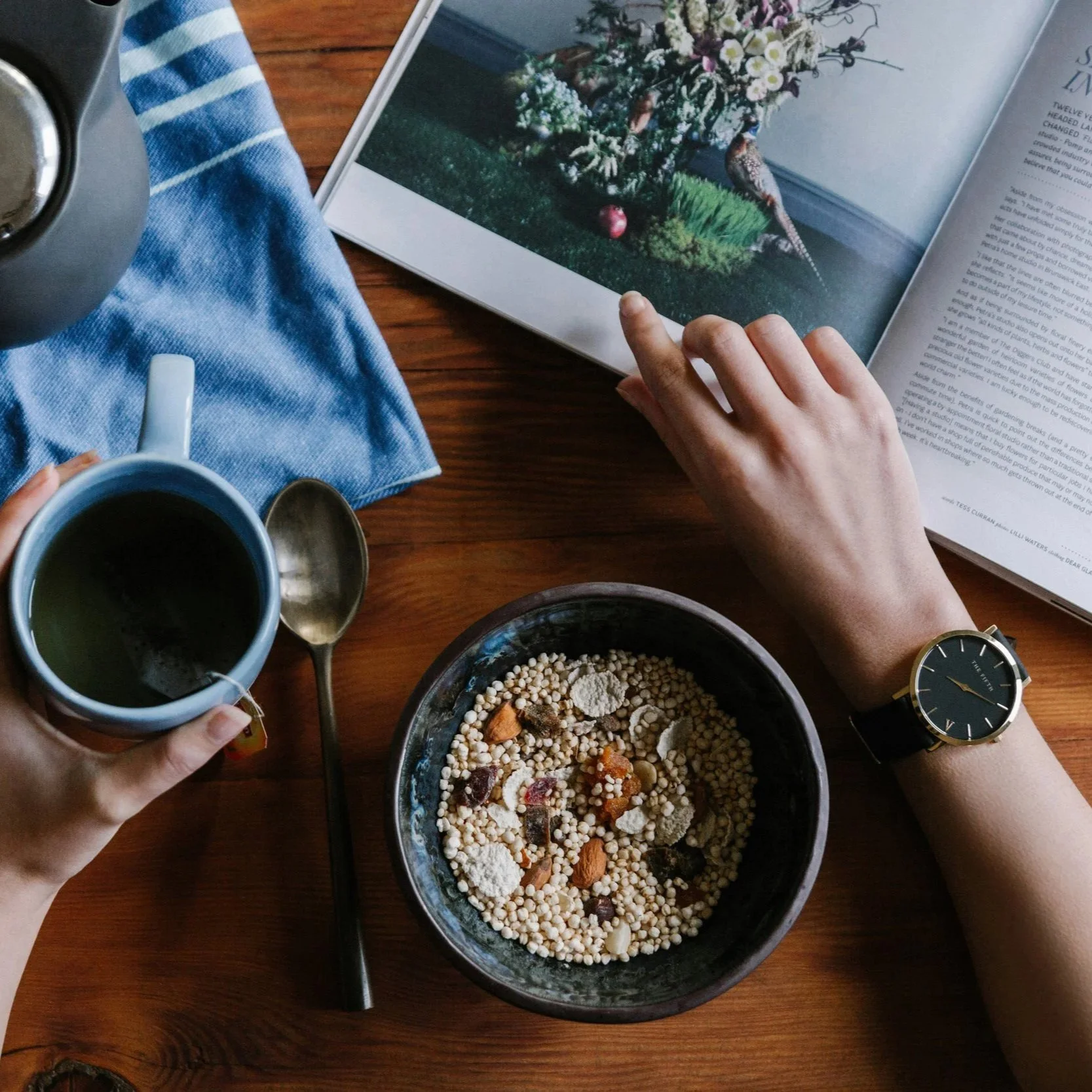 Person eating breakfast looking at nature photo book showing a bird.
