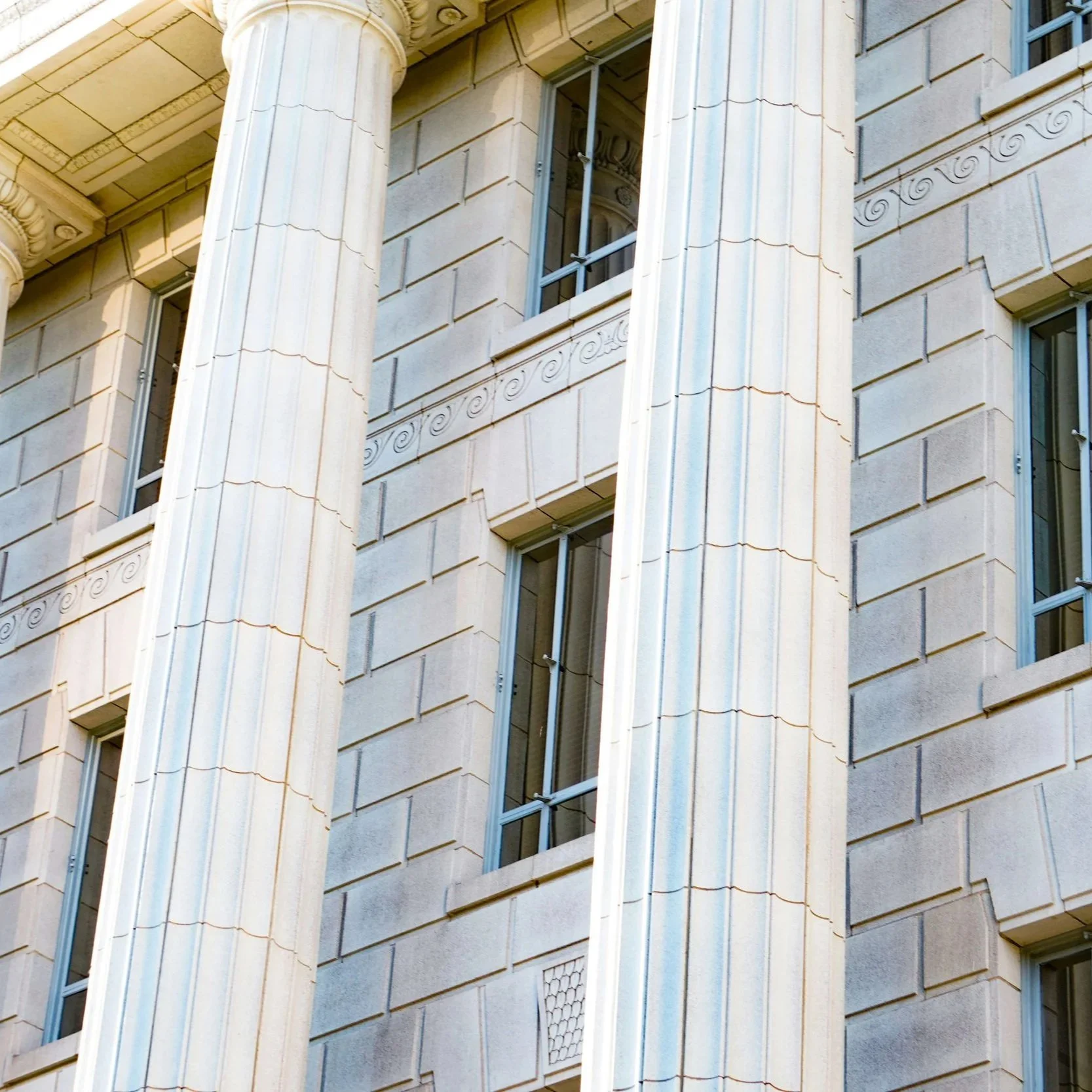Outside of government building showing large white columns.