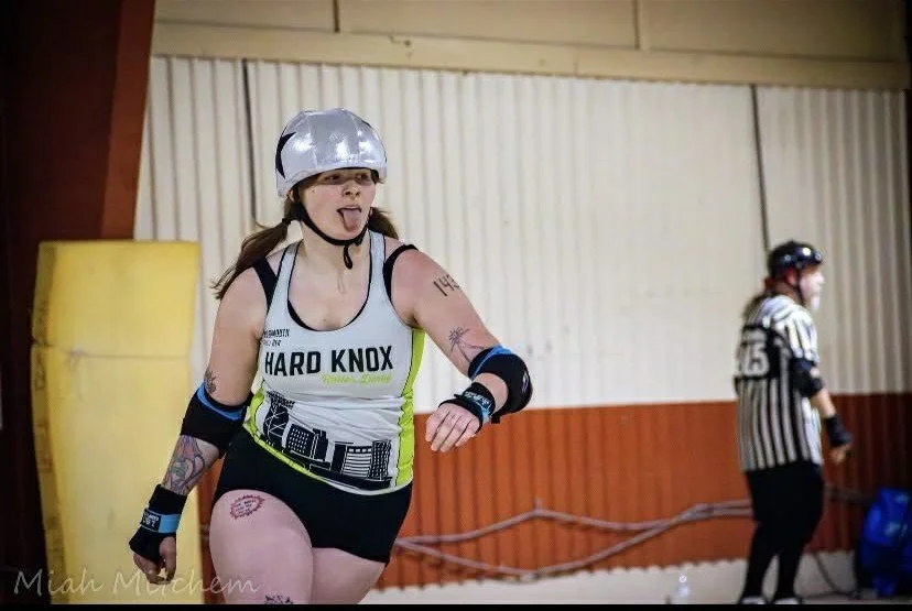 Panic skating around the track as she jams. Her tongue is out.