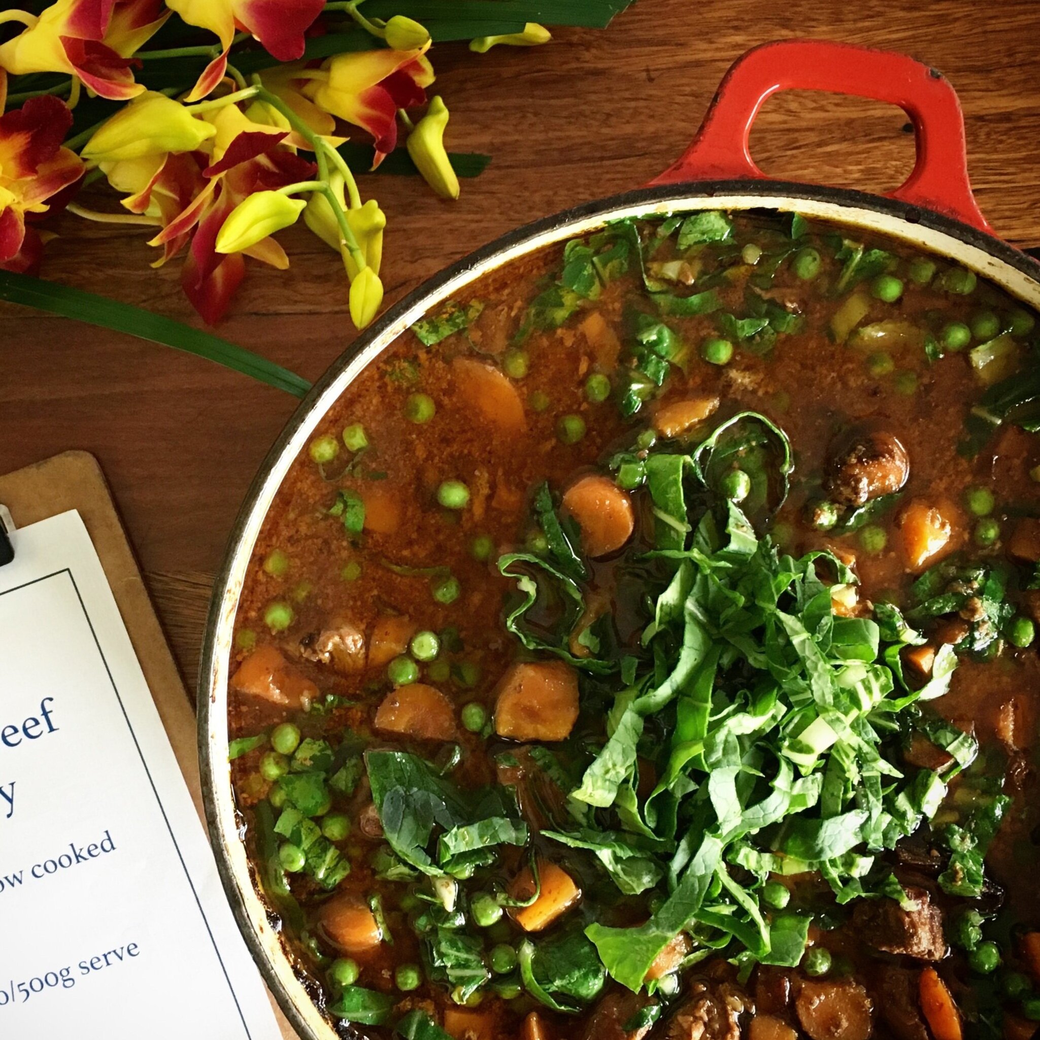 Hearty organic beef curry made with grass-fed beef, vegetables, bone broth, and curry spices, topped with greens and peas.