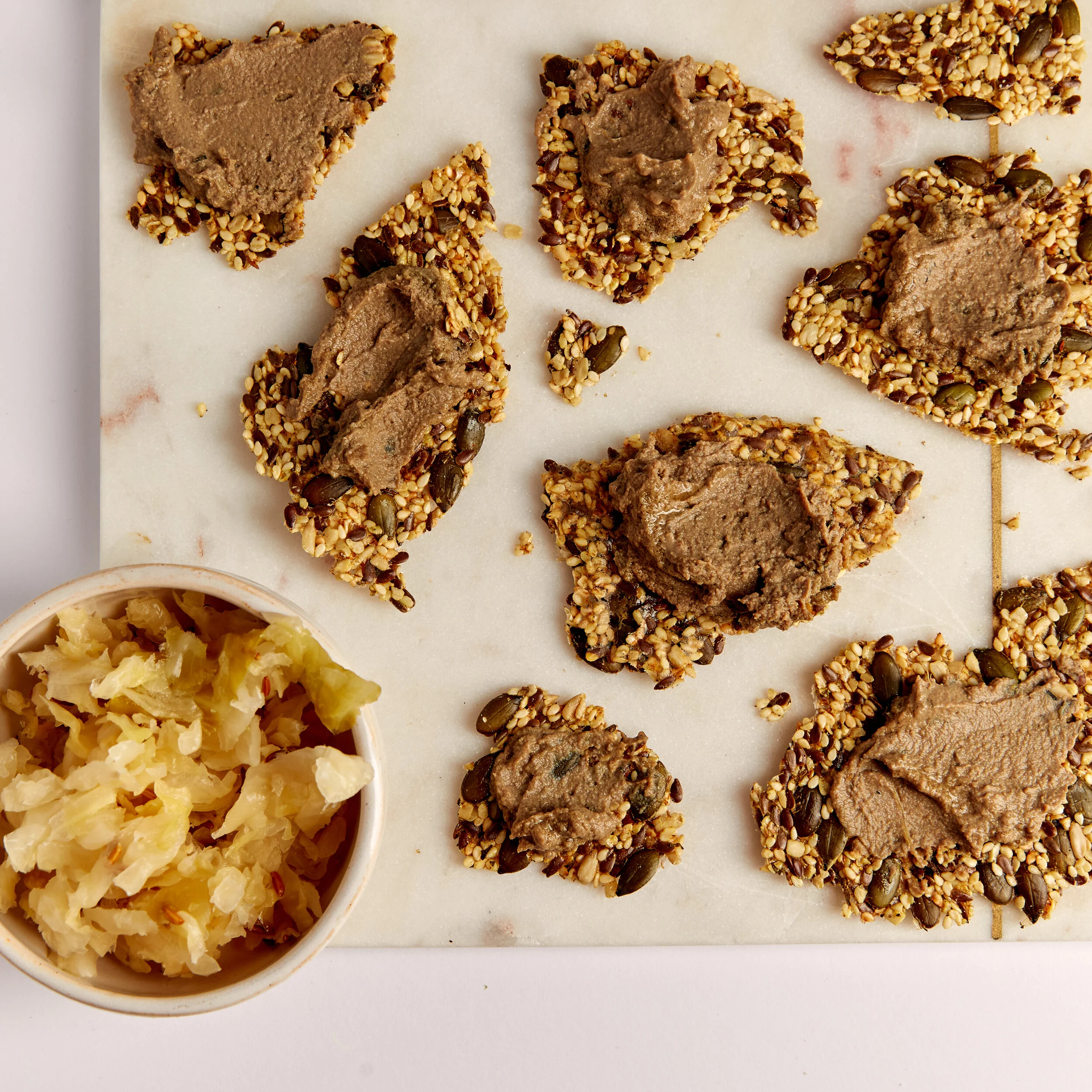 Organic pâté served on seed crackers with sauerkraut – rich in B12 and perfect for gut health