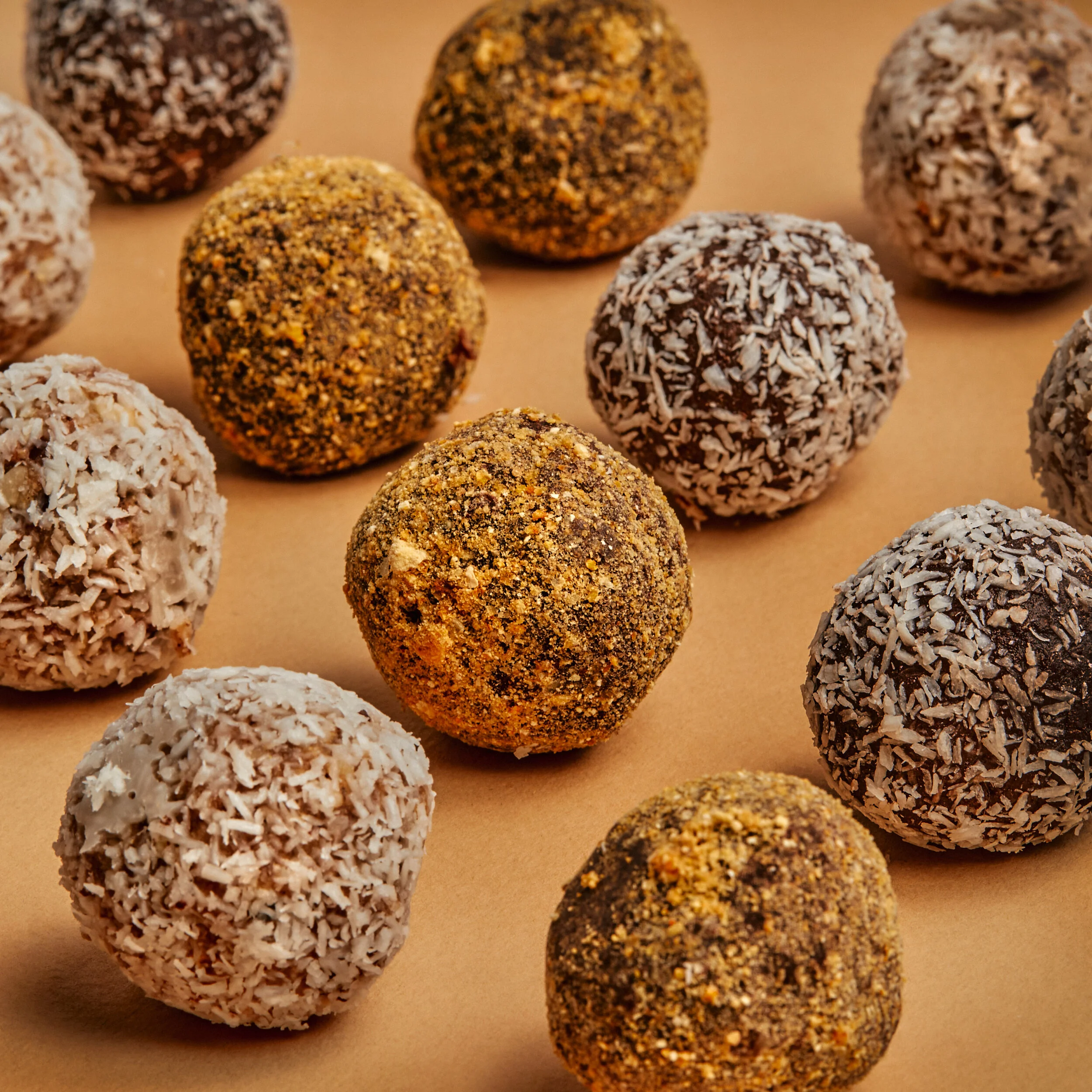 Close-up of handcrafted organic bliss balls rolled in coconut and turmeric – made with nutrient-dense, certified organic ingredients