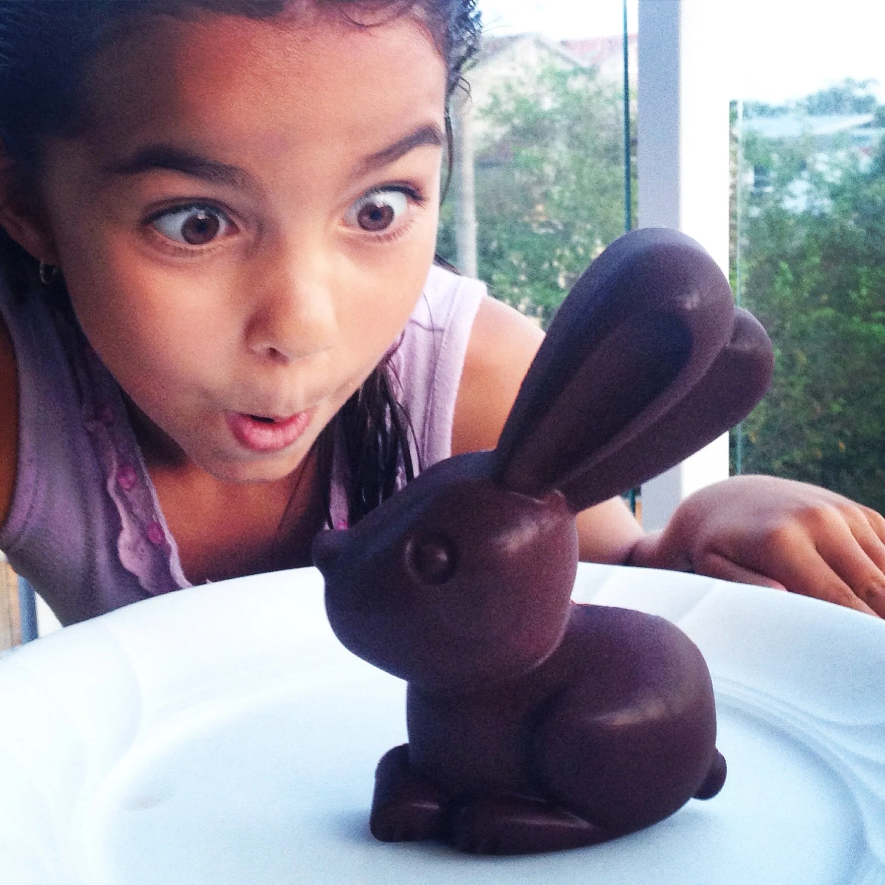 Excited child with organic chocolate Easter bunny – fun and wholesome seasonal gift