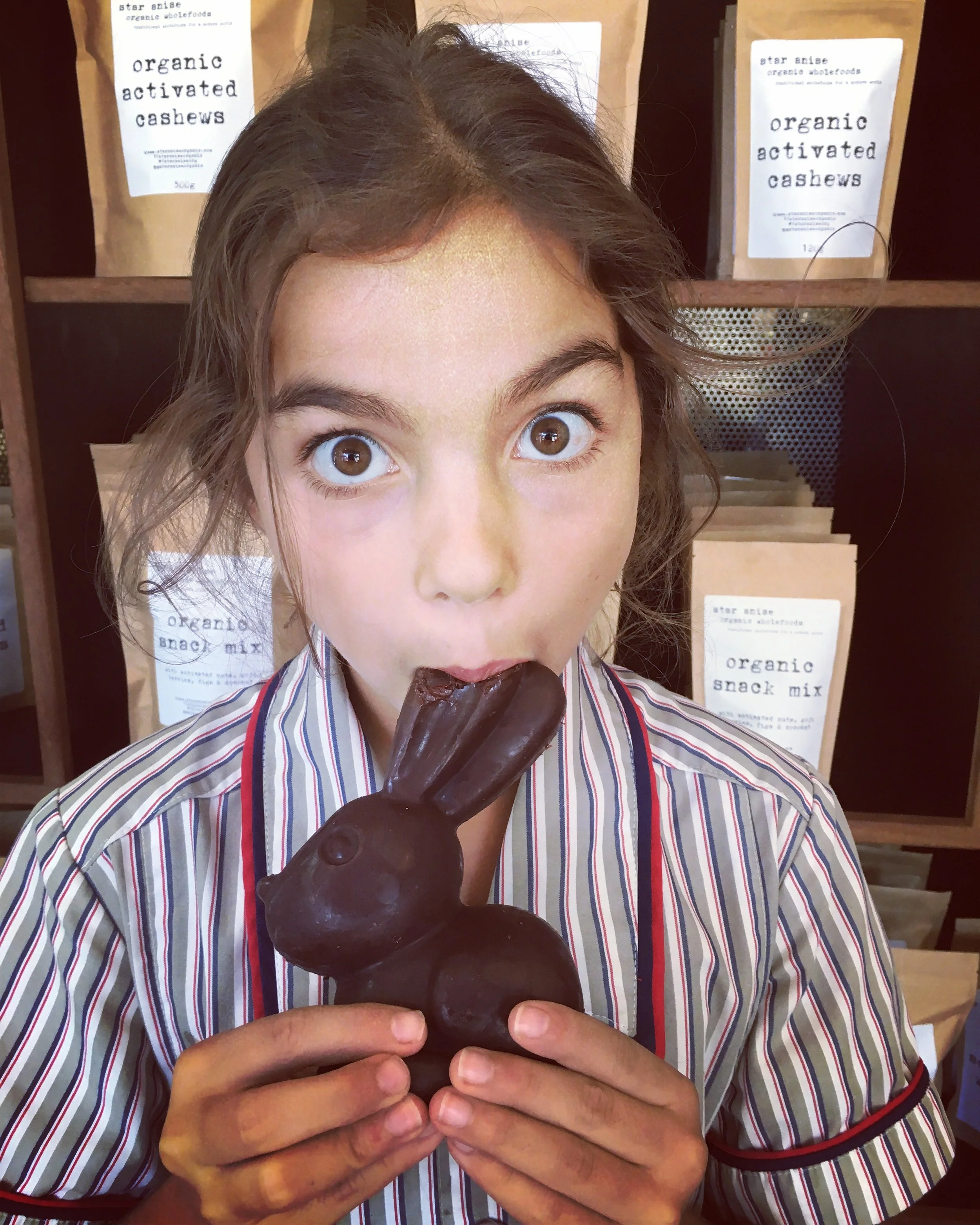 Child biting into handmade organic chocolate bunny – perfect for a natural Easter surprise