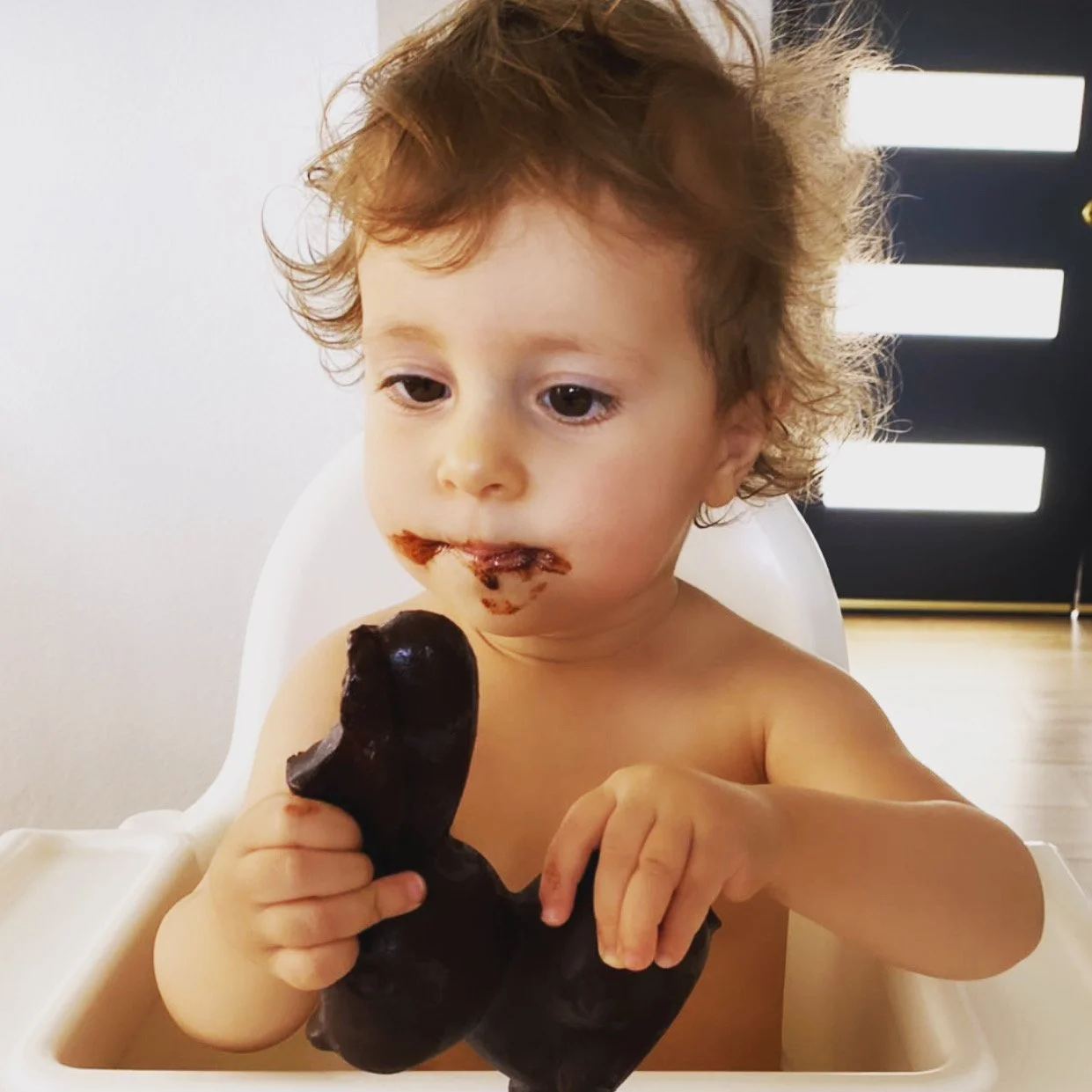Toddler holding raw chocolate Easter bunny – a clean, kid-friendly treat for Easter