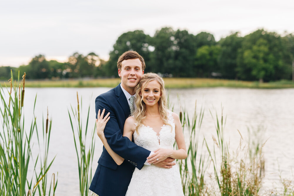 Bride and groom portraits on a farm by water