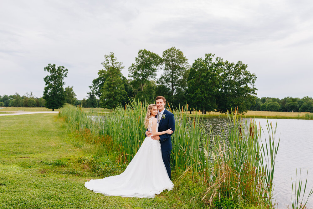 stunning bride and groom portraits by water on a farm