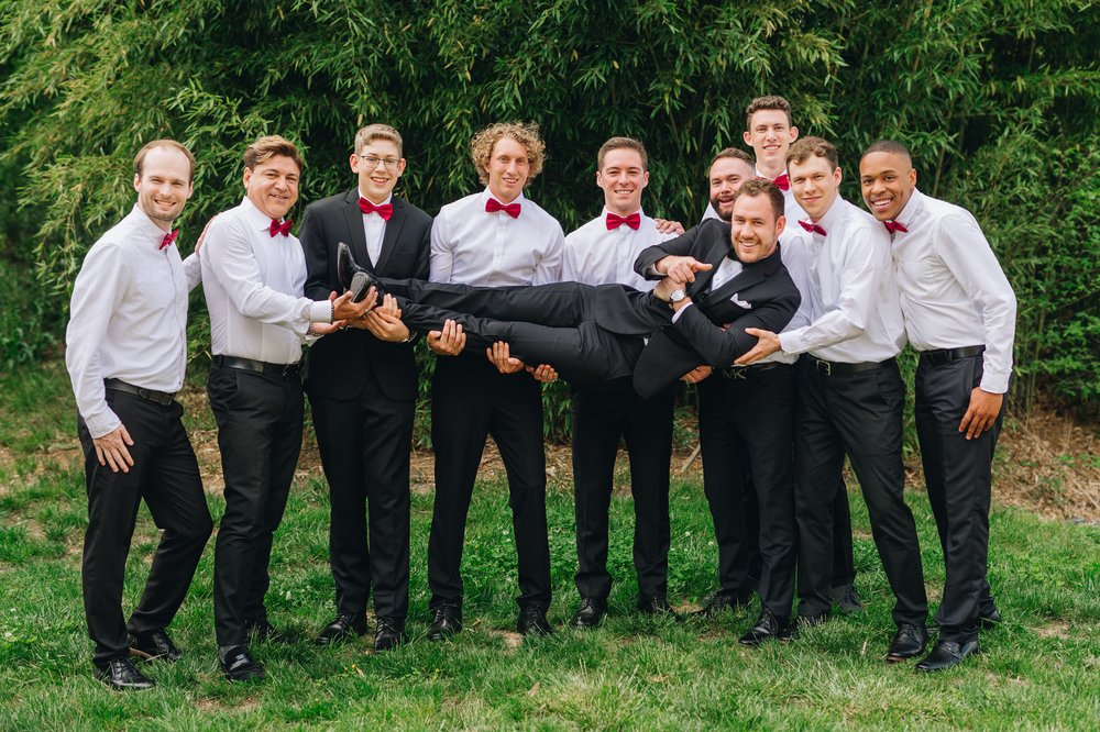 Groomsmen holding Groom photos