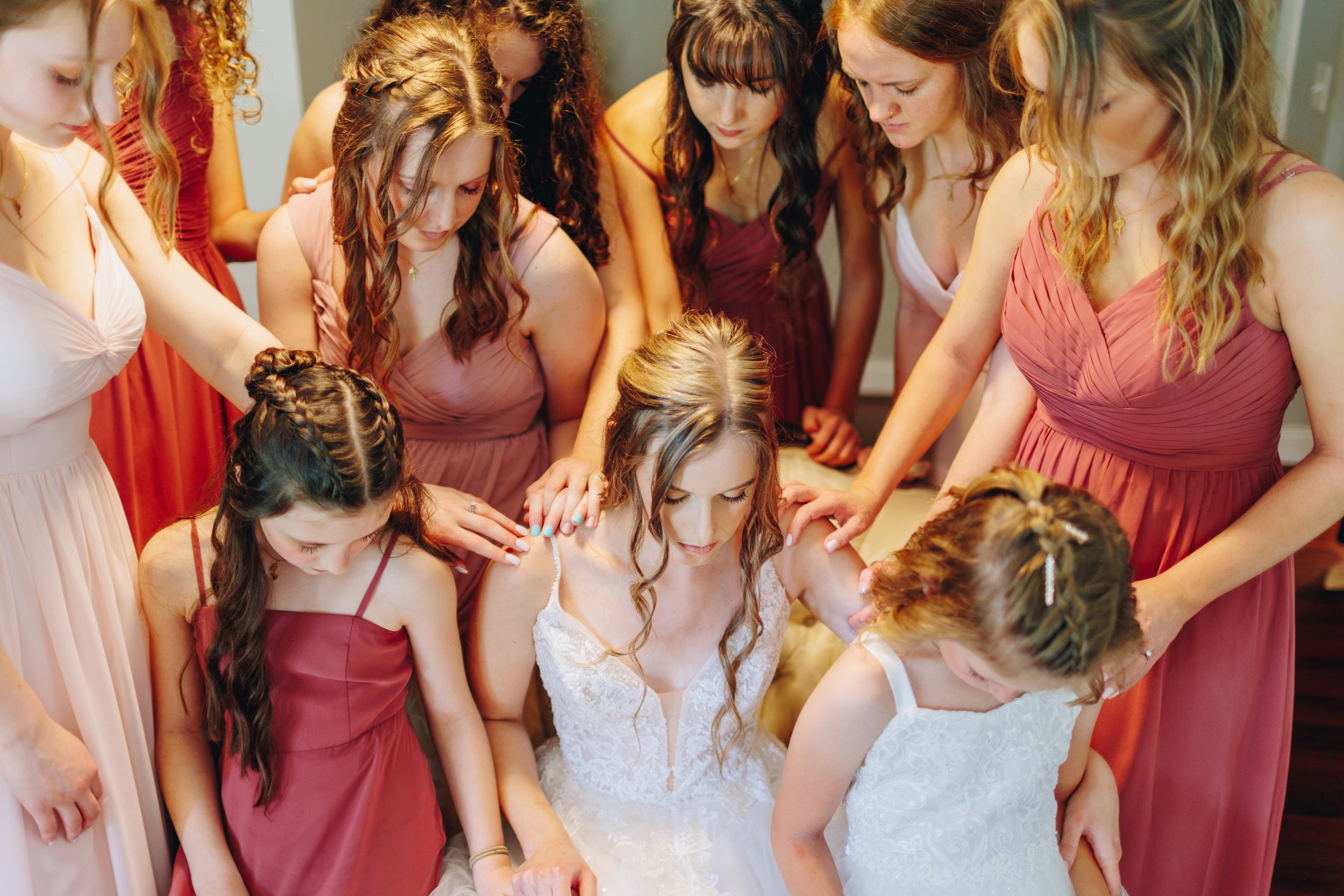 bridesmaids pray over bride photo