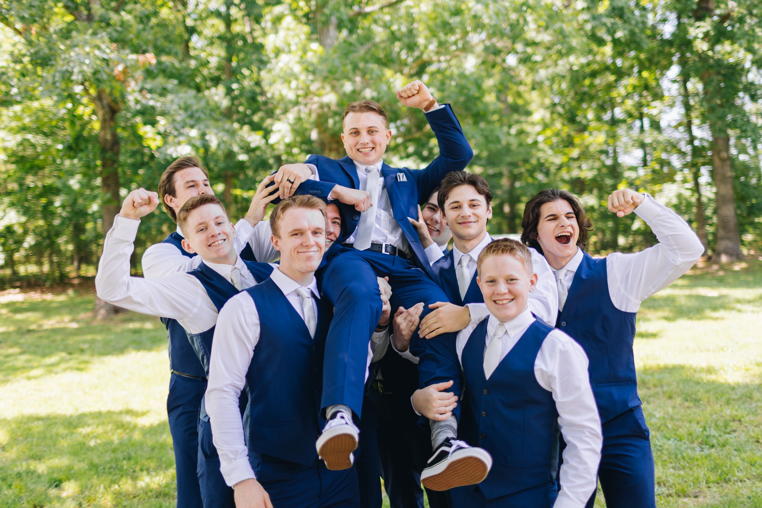 groomsmen holding groom portraits