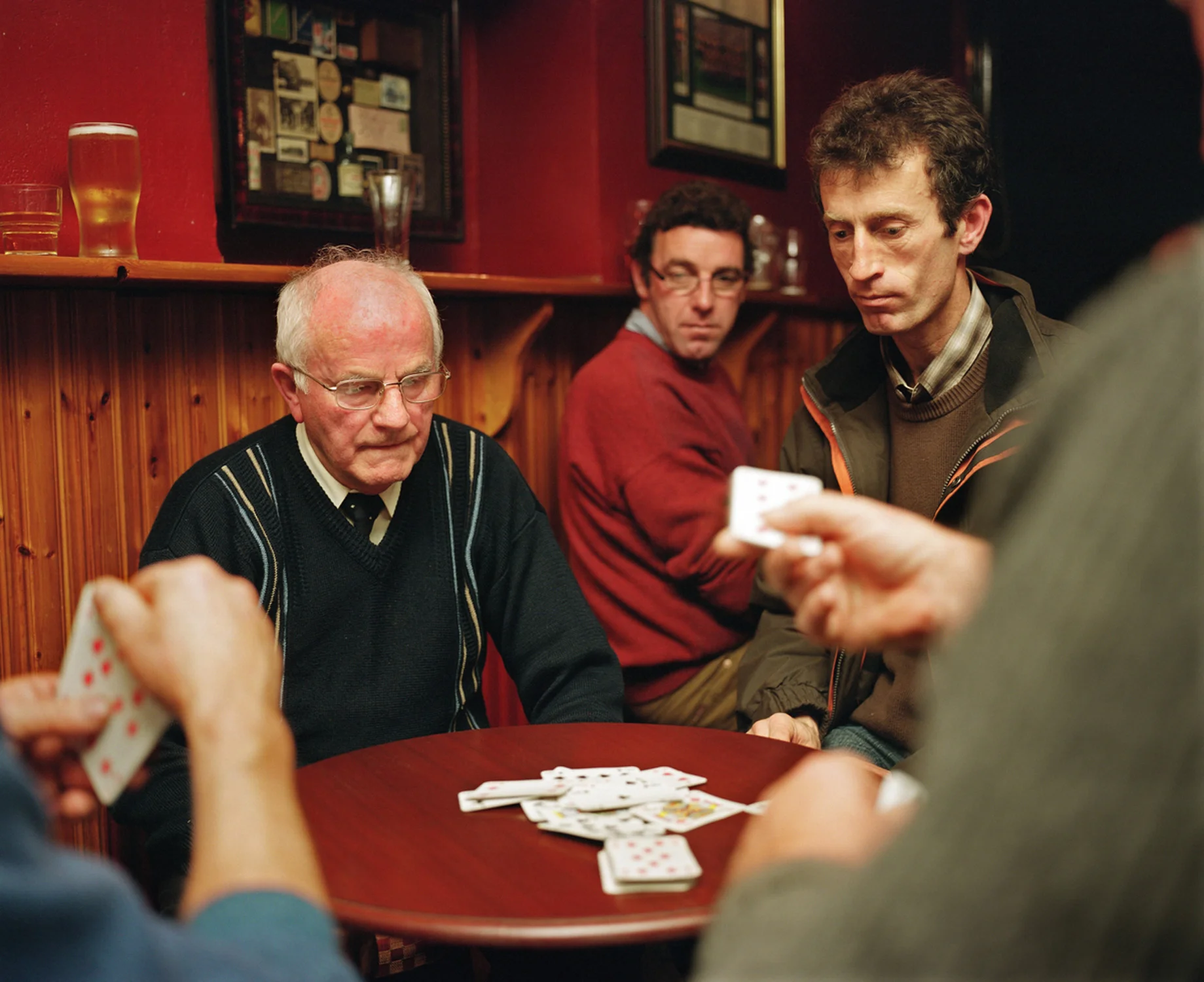 Though now a more secular society, Ireland still has remnants and relics of the old religious faith, even if many of its devoted followers are typically advanced in age – part of what might be termed a dying generation. The Catholic Church had been one of the country’s mainstays. Falling Mass attendances, declining priest numbers and various damaging scandals have shaken the institution and weakened its grip. Despite this my father is a daily Mass-goer; his faith doesn’t appear to have flinched. The house where I grew up in the west of Ireland is where my father now resides with his wife and their daughter Susan; all the rest of the family have flown the nest, some starting families of their own, one in New York where she has become part of the Irish Diaspora. The religious paraphernalia located throughout this house gives God a central presence and status not uncommon in Ireland at the time. We prayed as a family, like when the Angelus bells struck at noon and six in the evening. We knelt at night to say the Holy Rosary. Many of our rites of passage as children were rooted in Catholicism – our first communion, our confirmation, and so on. My father, who is 85, would not have seen anything remarkable in this. He was merely carrying on the tradition of his own father’s generation. Having spent half his life working, he recently retired, closing his drapery store. His undertaker’s business continues. For me and others in the family it meant that death was never far away or overtly mysterious. We became accustomed to the dead of our parish being prepared for the final ceremonies before burial. We would often come home from school to see who had died that day. If we truly wanted to make our father proud, we would have mastered the game he followed all his life: hurling. This ancient Irish sport, requiring great dexterity, courage and speed, can still weave a spell on him. Born in a rural community he has seen his own life change and now that of his children too. In recent years he lost a brother to whom he was close. Now I see him deriving great joy from his grandchildren. In their company he seems tranquil. At peace. His work done.