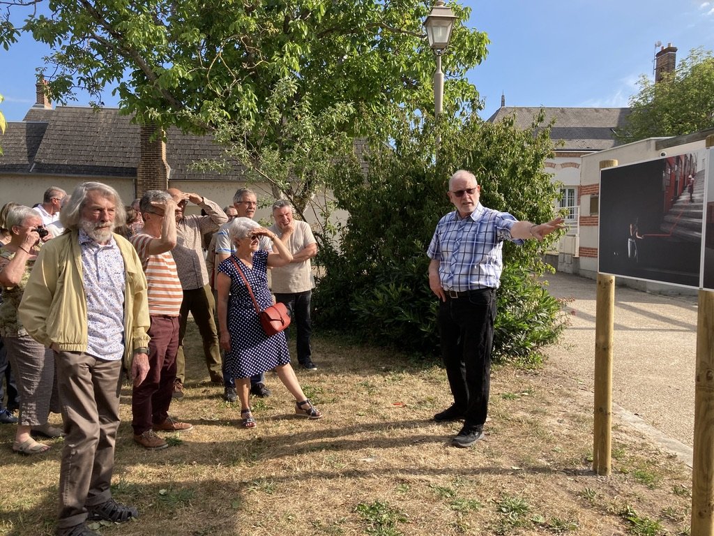 François Lievin présente la photographie "la limite" d'Anne Bouquier devant la mairie de Saint Denis en Val