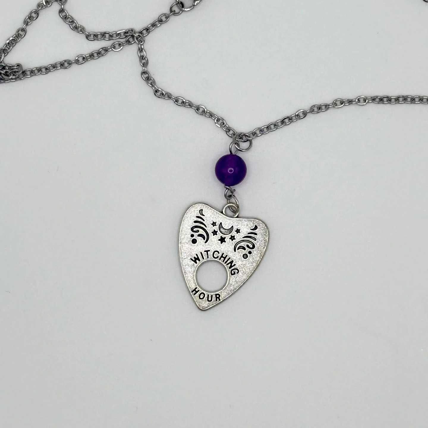 **🌙✨ Witching Hour Planchette Necklace ✨🔮** 

Embrace the magic of midnight with our **Witching Hour Planchette Necklace**&mdash;a spellbinding piece designed for those drawn to the mysteries of the unknown. Featuring a **metal alloy planchette cha