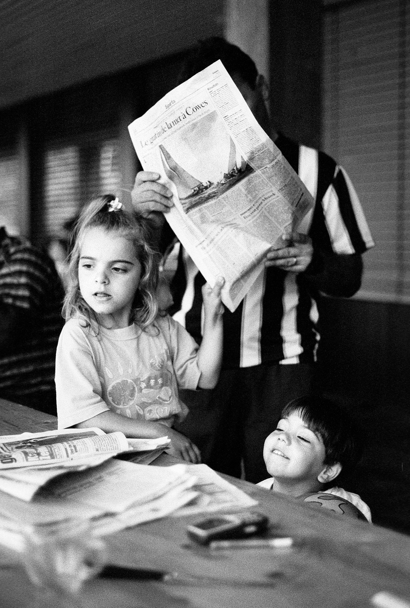  Les sans-papiers font les gros titres aujourd'hui. Un père de famille lisant le journal du jour.&nbsp;Fribourg, le 21 août 2001. 