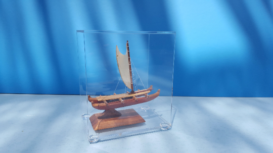 A Hawaiian miniature sailing canoe carved using koa wood and long by 4"1/2