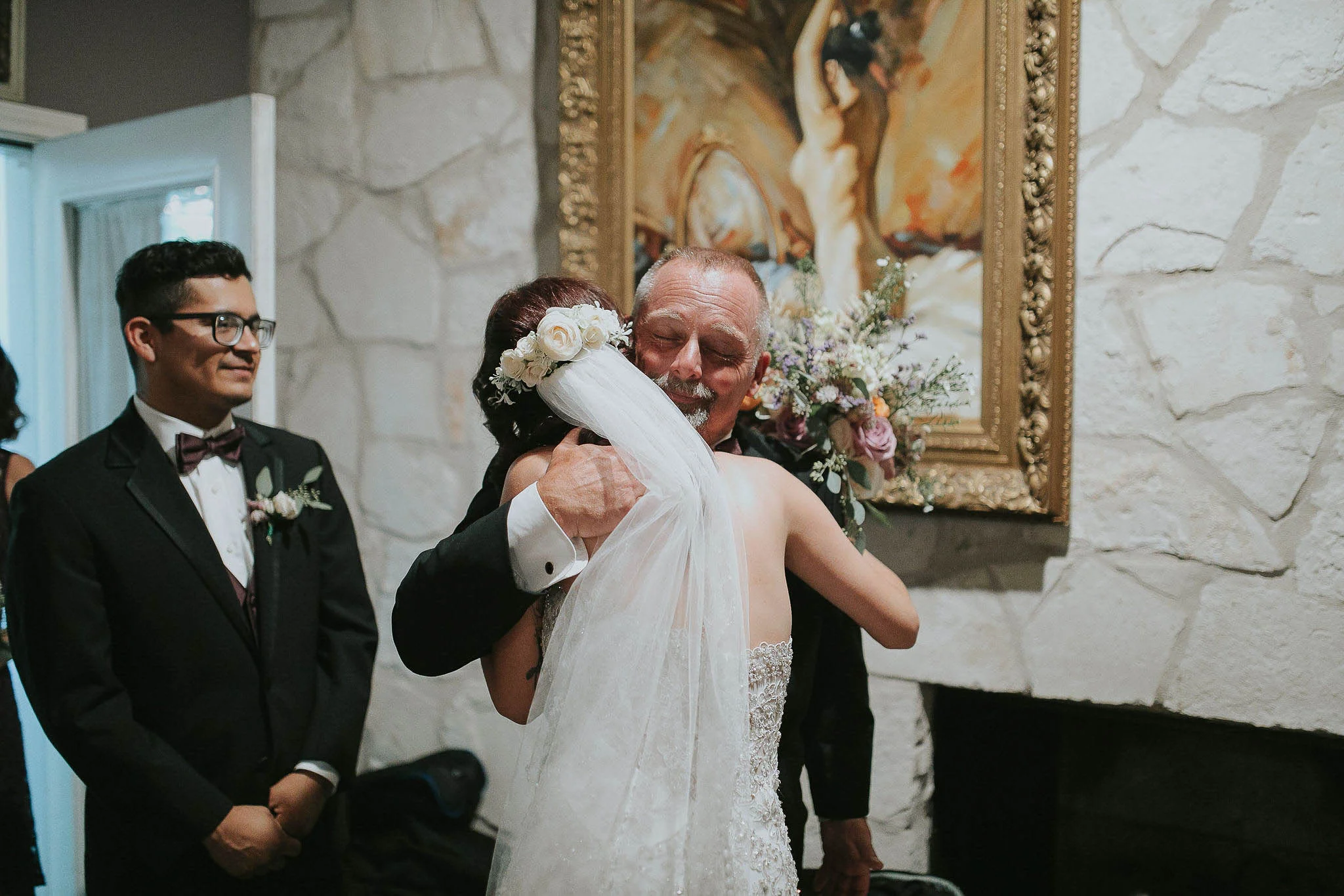 Father of the groom embraces his new daughter in law after the wedding ceremony. Shot at Casa Blanca Austin Texas by David C. Allen Photography.