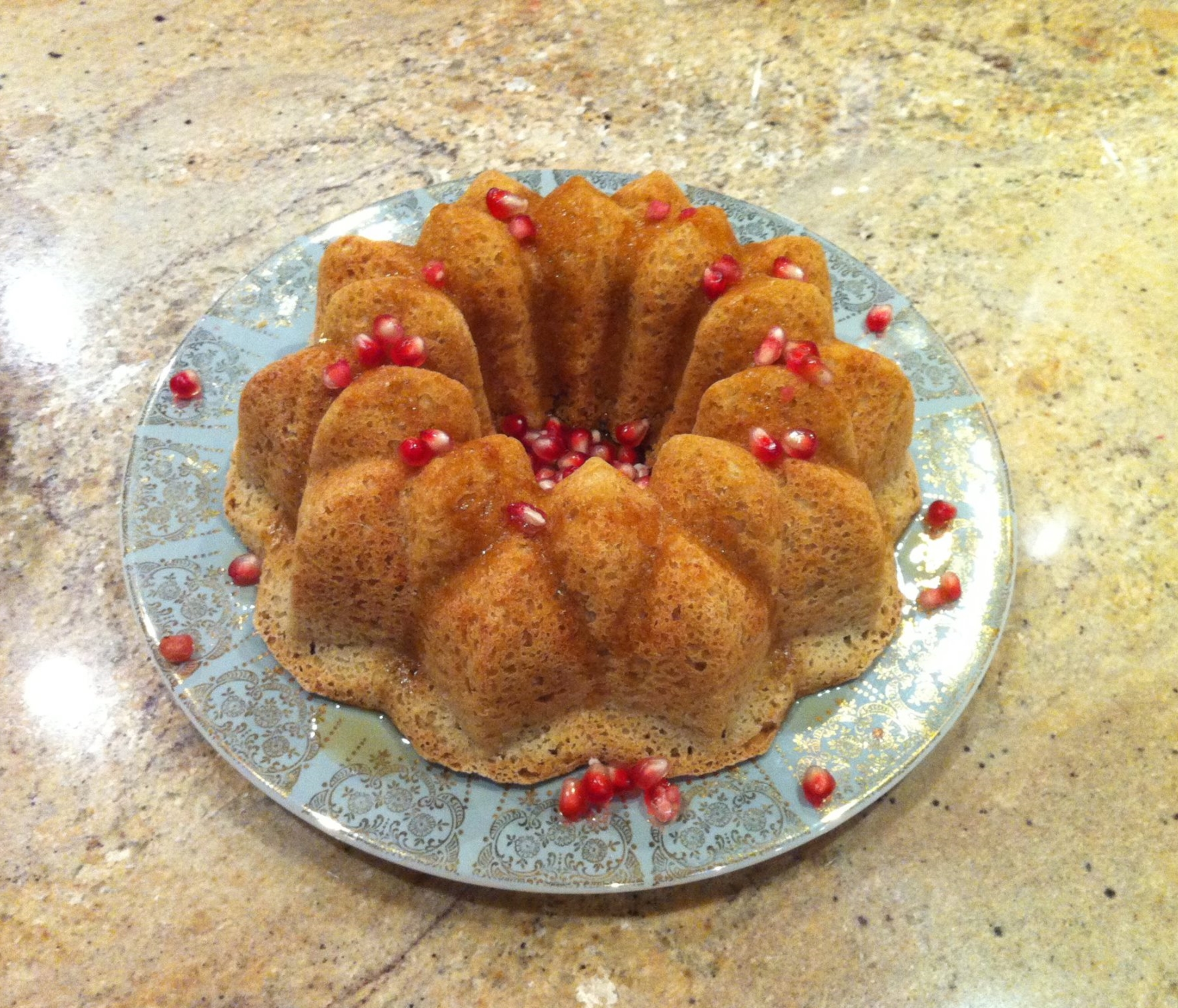 Posh Belly's Kitchen's Gluten Free Oat Challah Plated with Pomegranate Seeds and Maple Syrup for Rosh Hashanah Celebrations