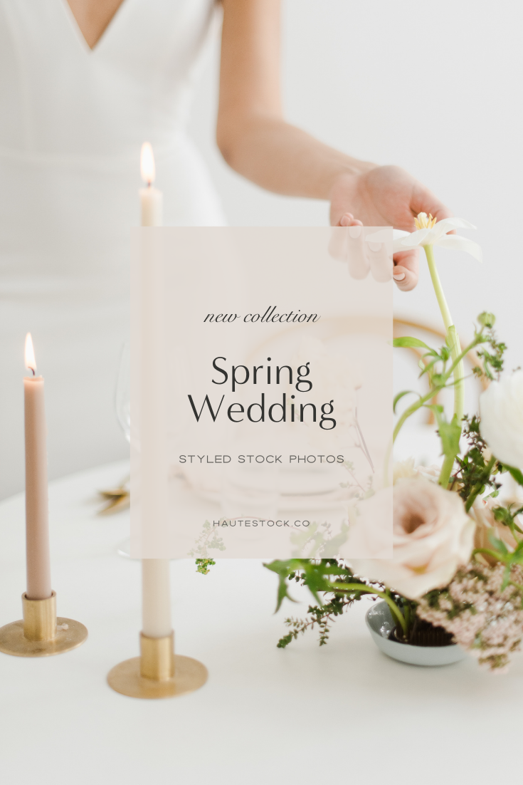 Neutral & blush spring wedding styled stock photography featuring woman in wedding dress setting tablescape with candles and delicate flowers.