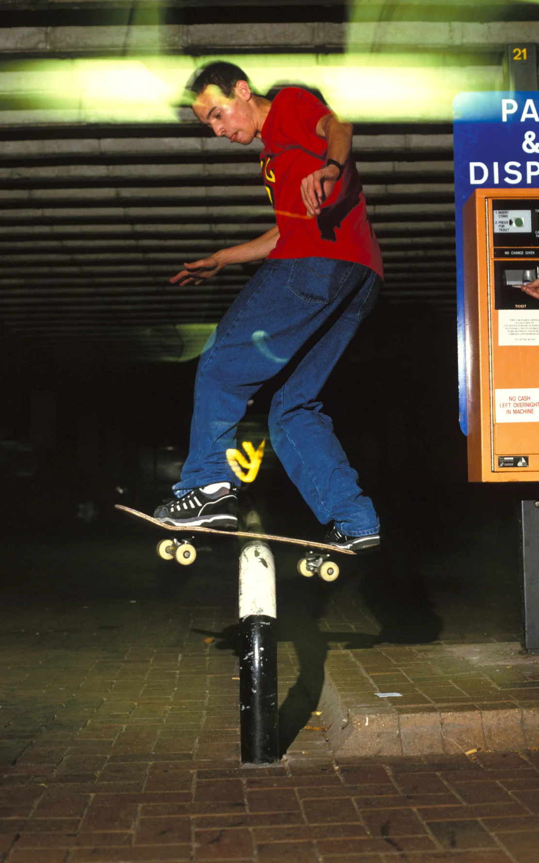 Skater, Robert Jaye, doing a rail-slide on a metal barrier in a car park, UK, 2000's . © Styley / PYMCA