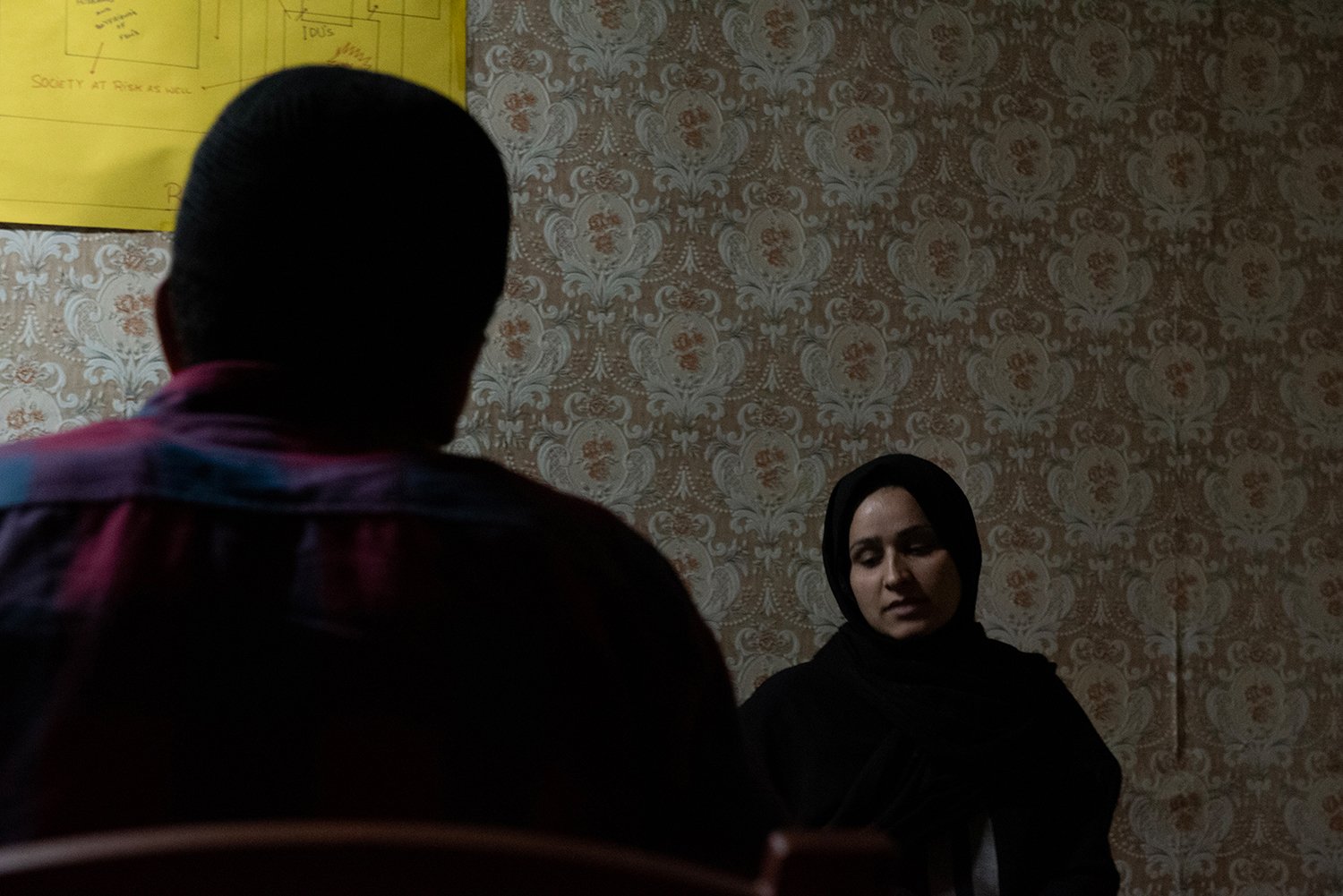  A service user (foreground) talks to a social worker (background) during a counseling session in a drug de-addiction center in Kashmir. 