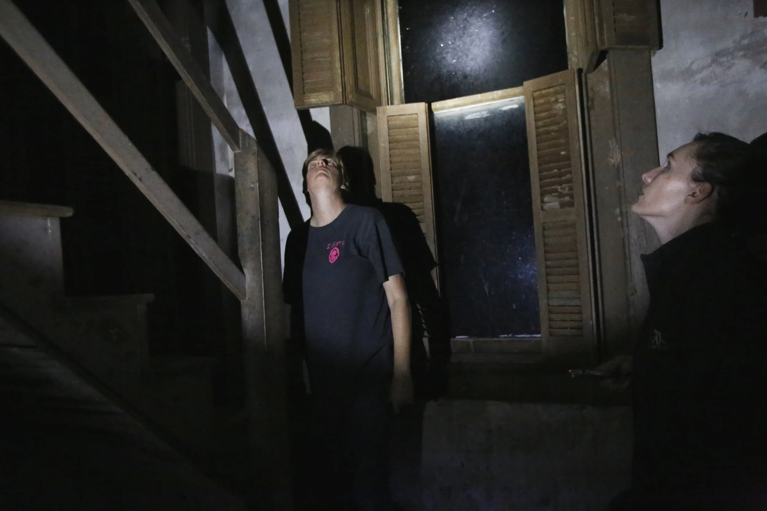 LIPS members Angela Rutherford and Niki Carver hear a noise above them while investigating Ravenswood in Bunceton, Mo. Saturday, Oct. 25, 2014. They both look up simultaneously, the door was locked and that part of the house was shut off to the team.