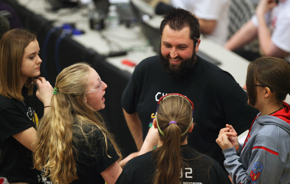  From left, Hannah Engler, 15, Kaitlyn De Kan, 17, Allie Floyd, 18, and Shannon Coupland, 17, talk with their coach, Adam Arnold, during the VEX Missouri State Robotics Championship in Rolla on Saturday. The team won three awards based on their perfo