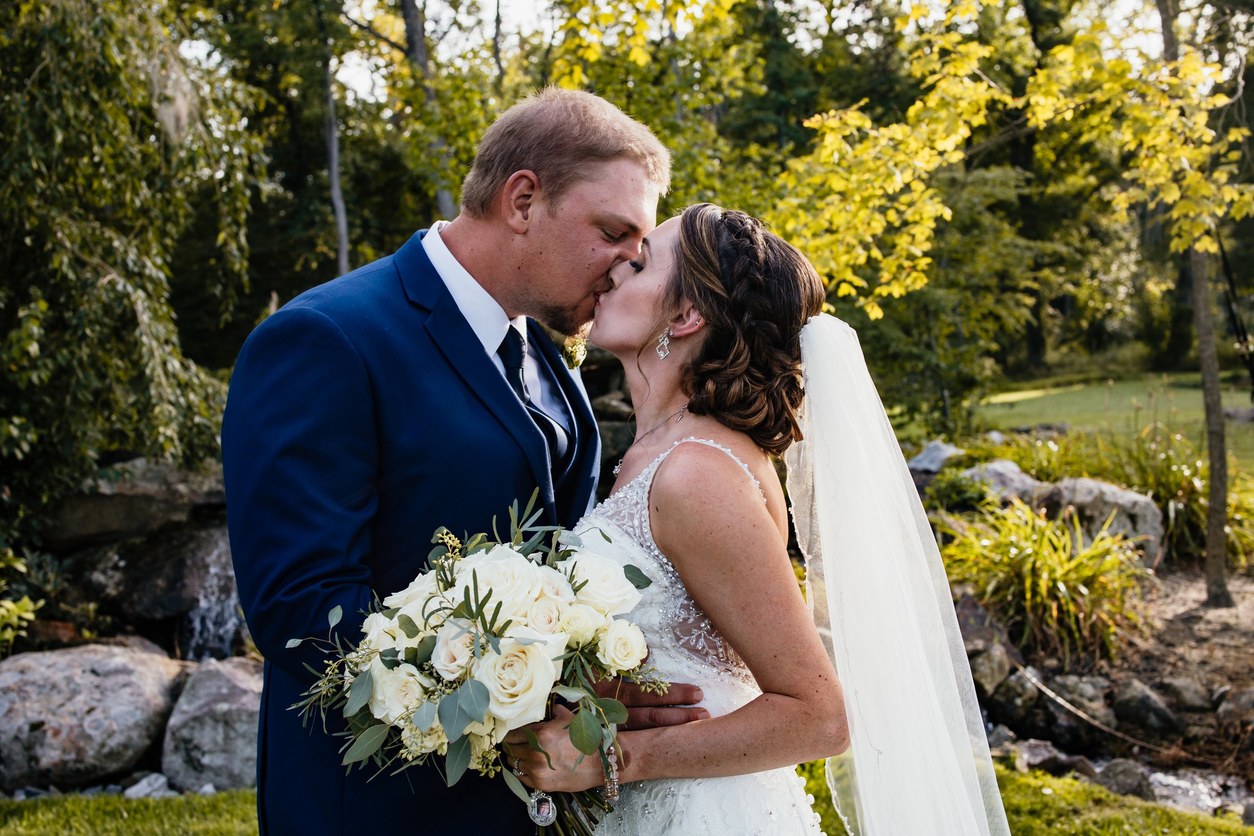 A bride and groom kiss, close up.