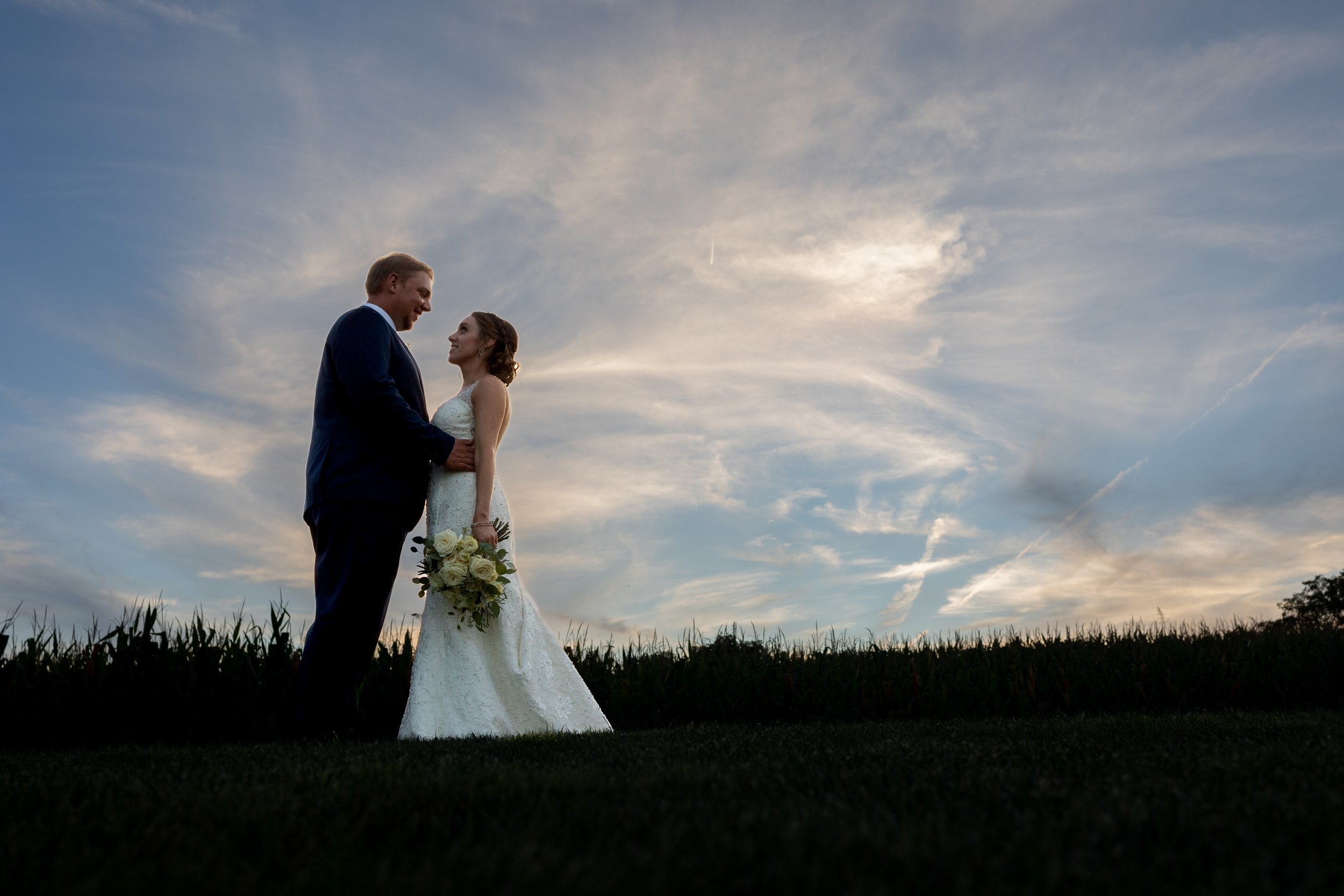 Wedding poses of couple with sunset sky.