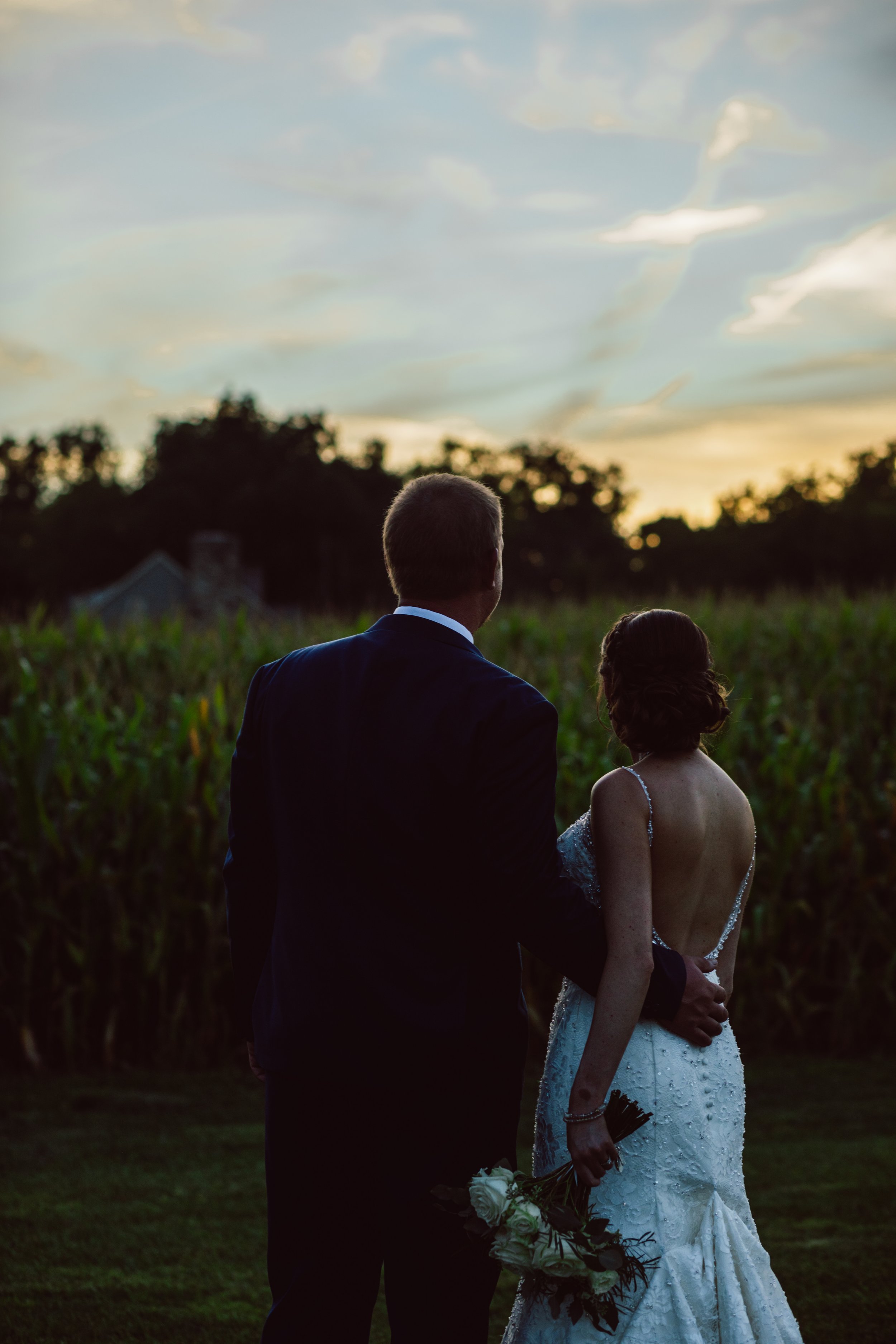 Wedding couple looking out at sunset.