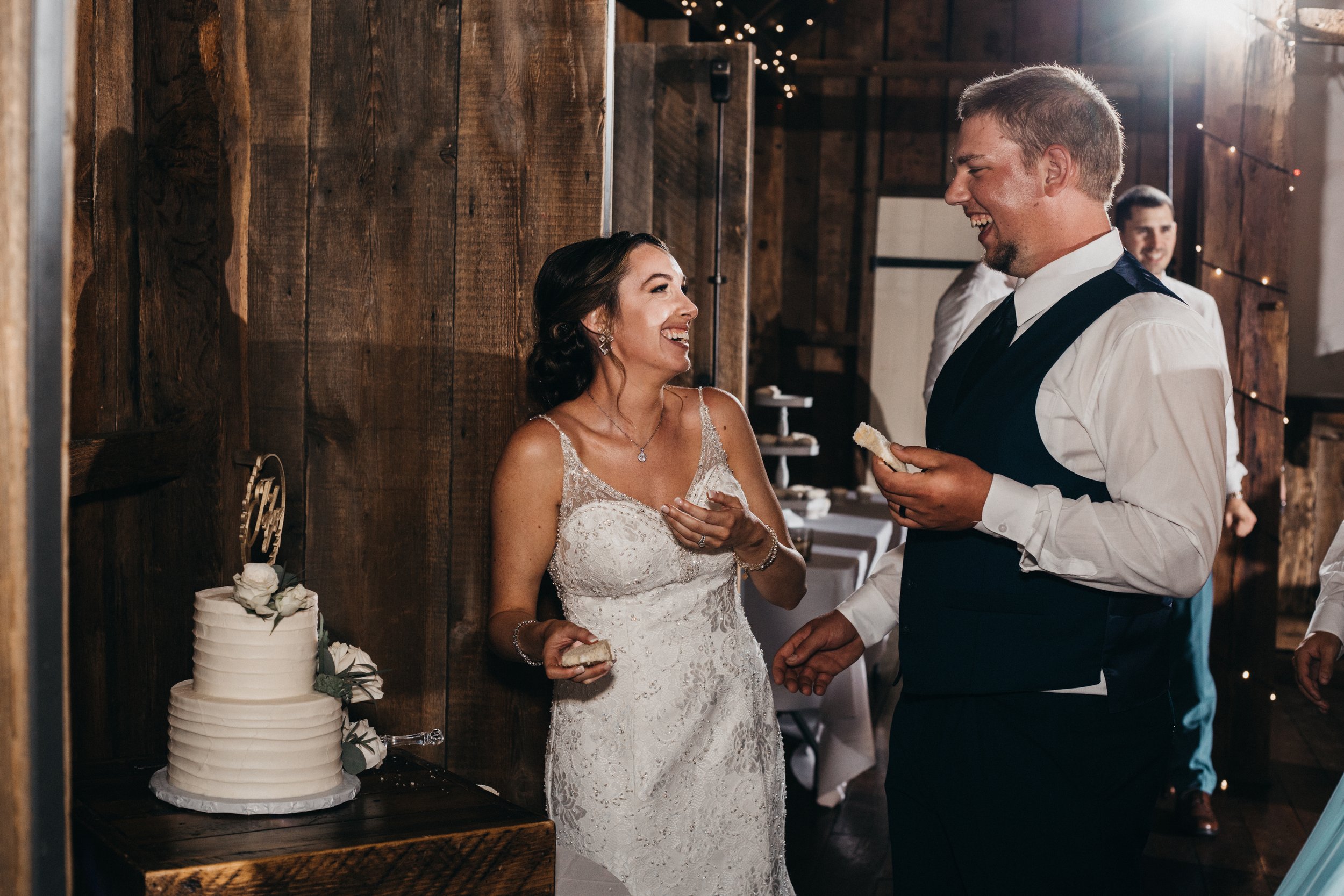 A bride and groom with their wedding cake.