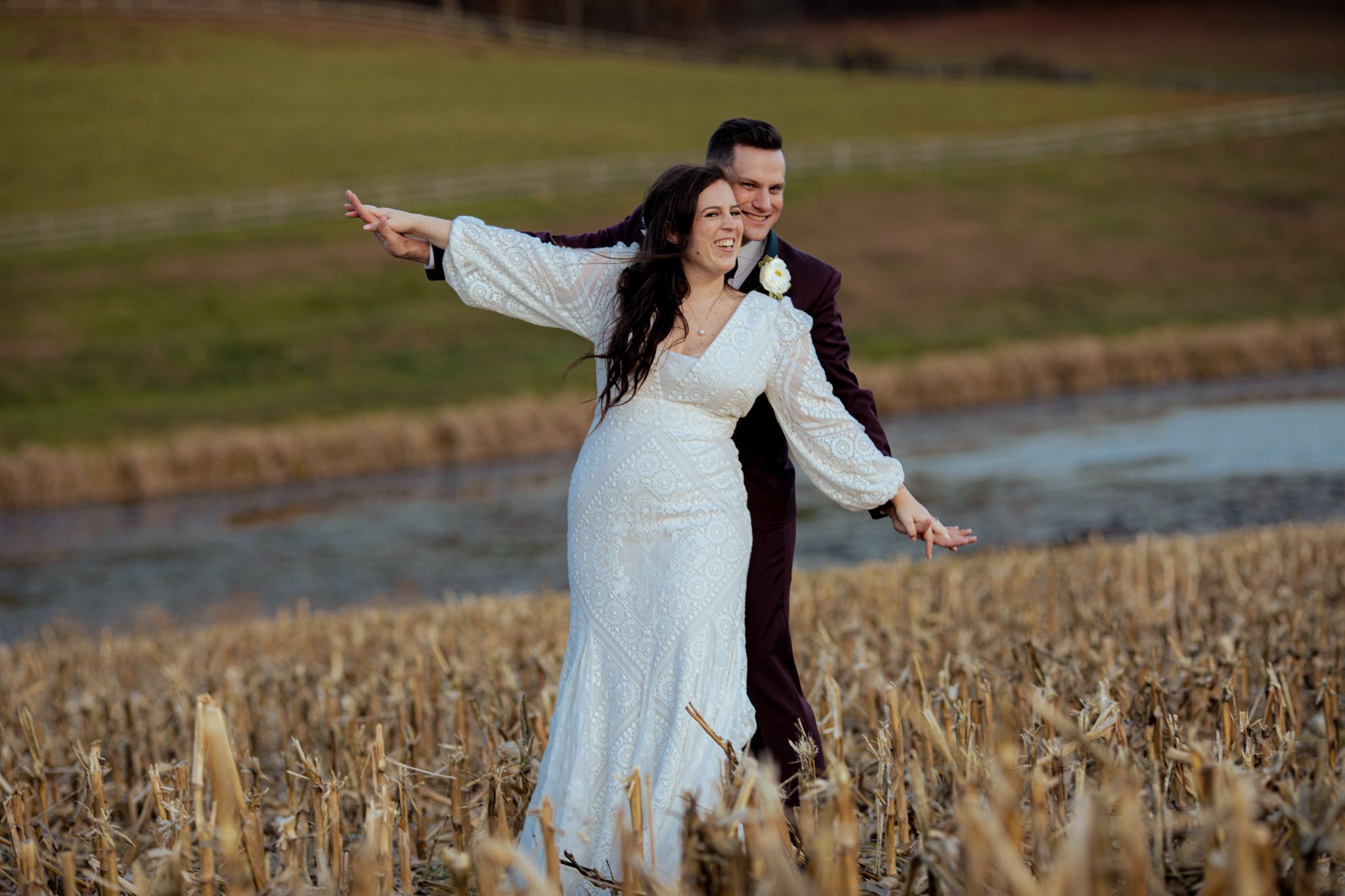 A bride and groom play airplane together for a portrait.