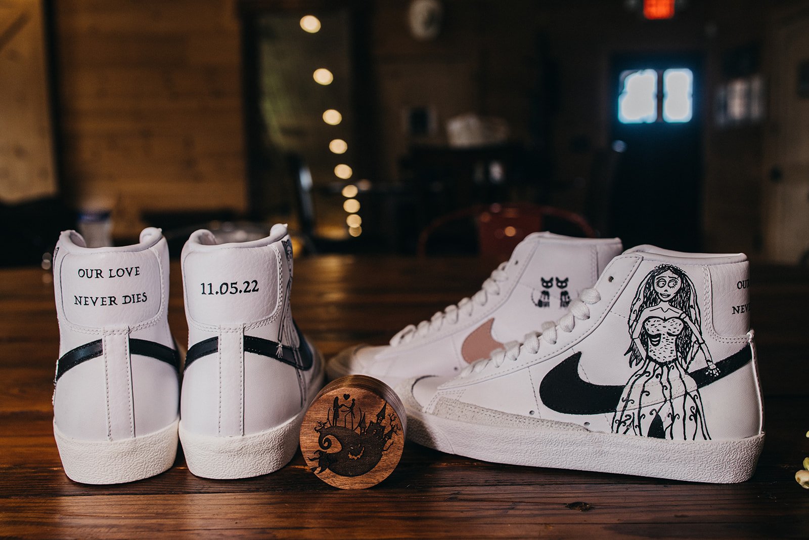 Two Nike shoes painted with Nightmare Before Christmas and a wedding date.