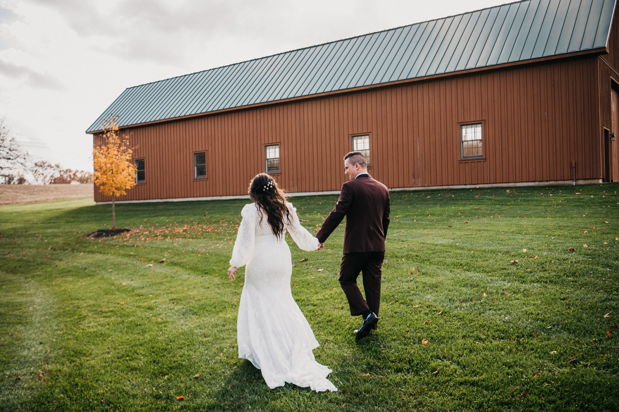 A bride and groom hold hands at Turner Crossings Farm Parkton Maryland.