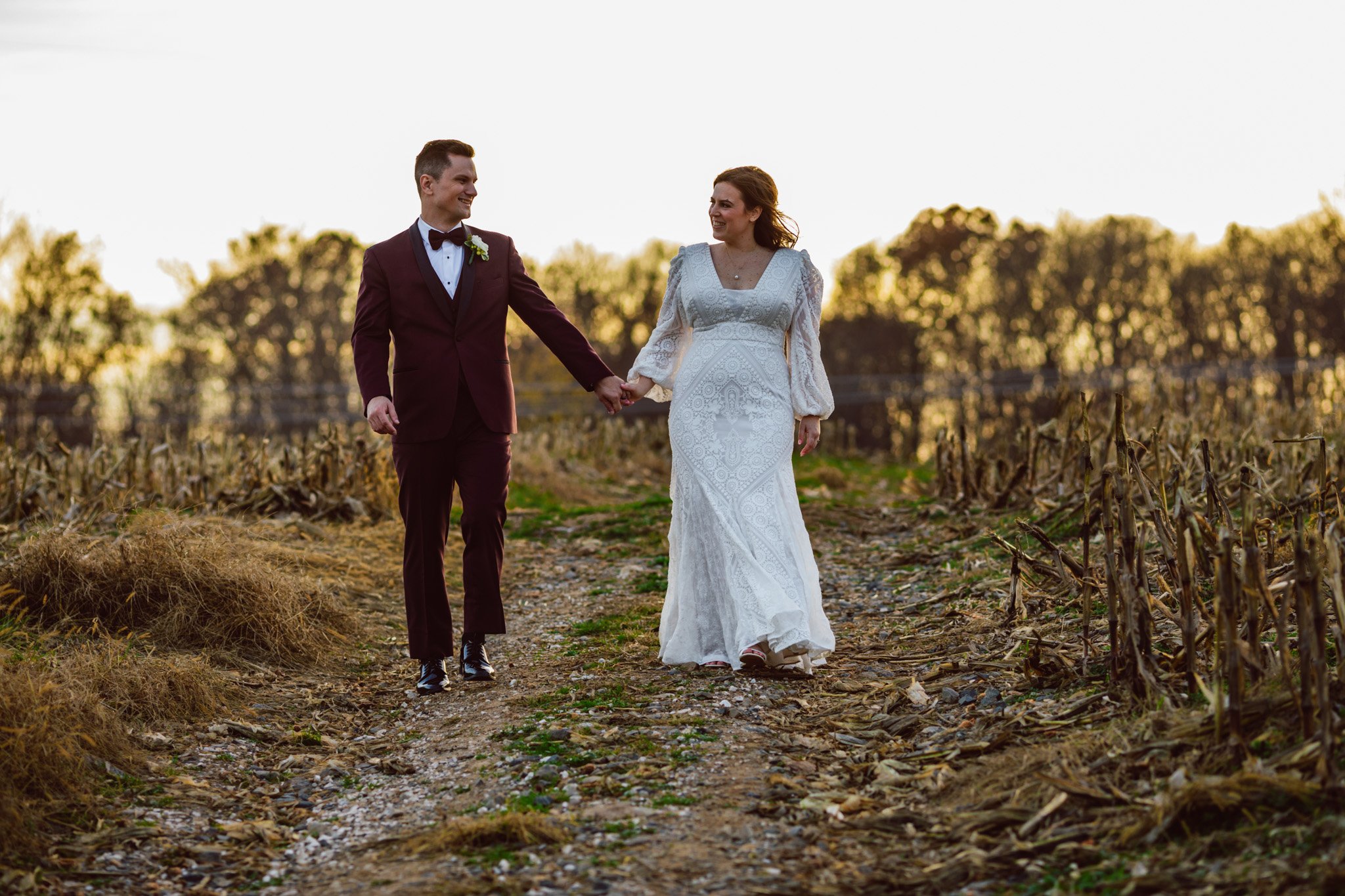 A wedding couple, bride and groom holding hands at sunset atTurner Crossings Farm in Parkton Maryland.