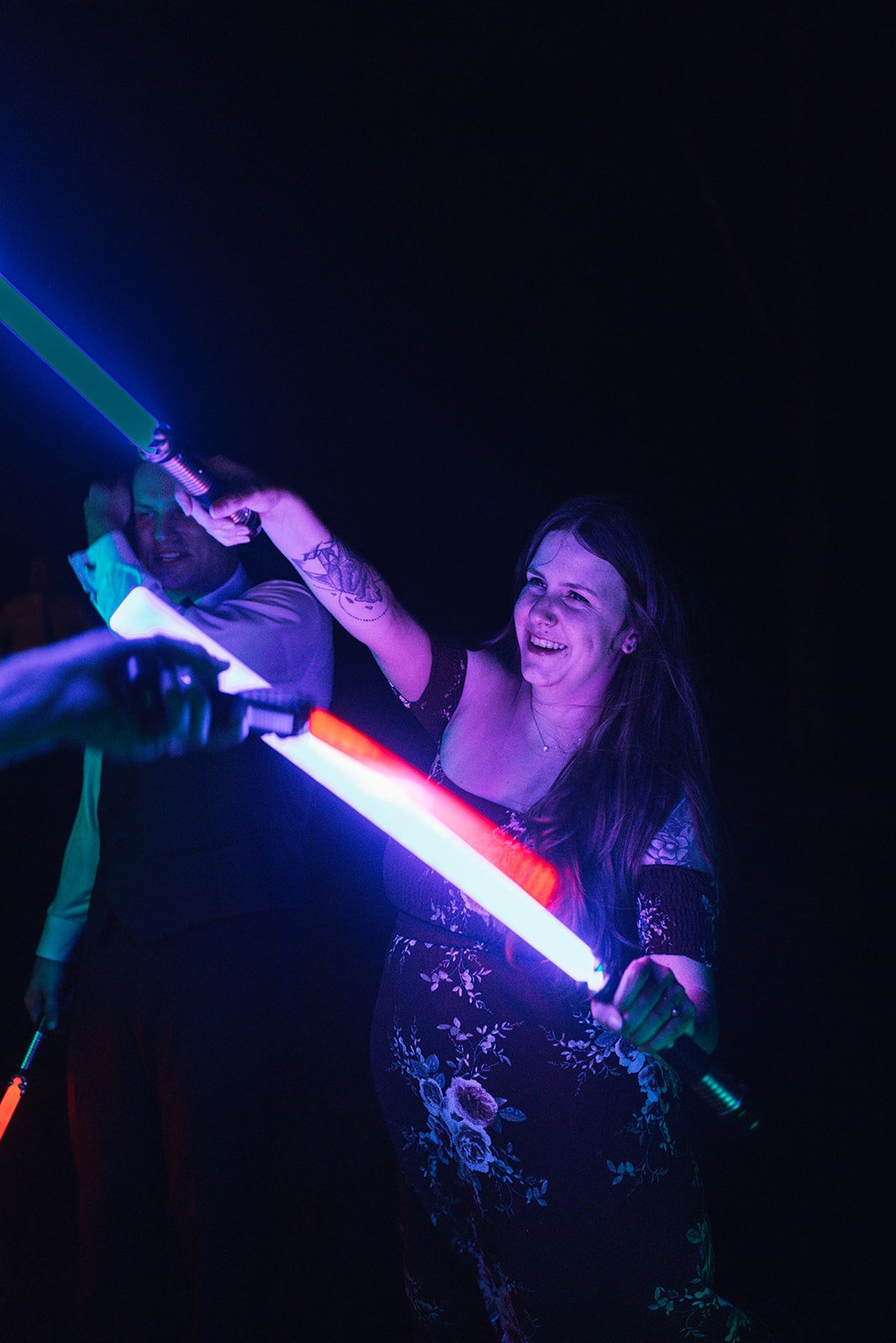 A photo of a wedding guest with a purple lightsaber.