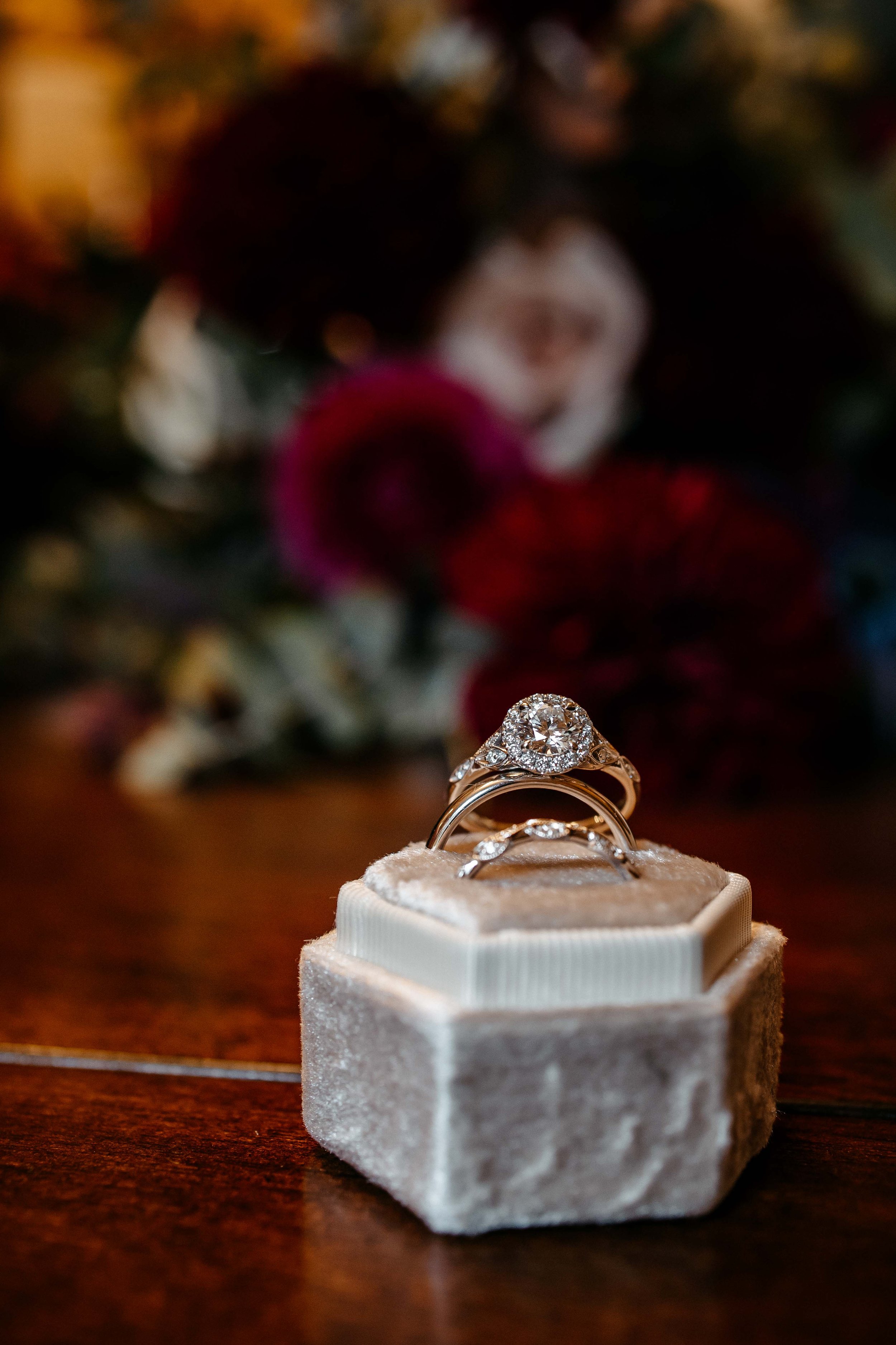 a close up of wedding rings and a bouquet of flowers.