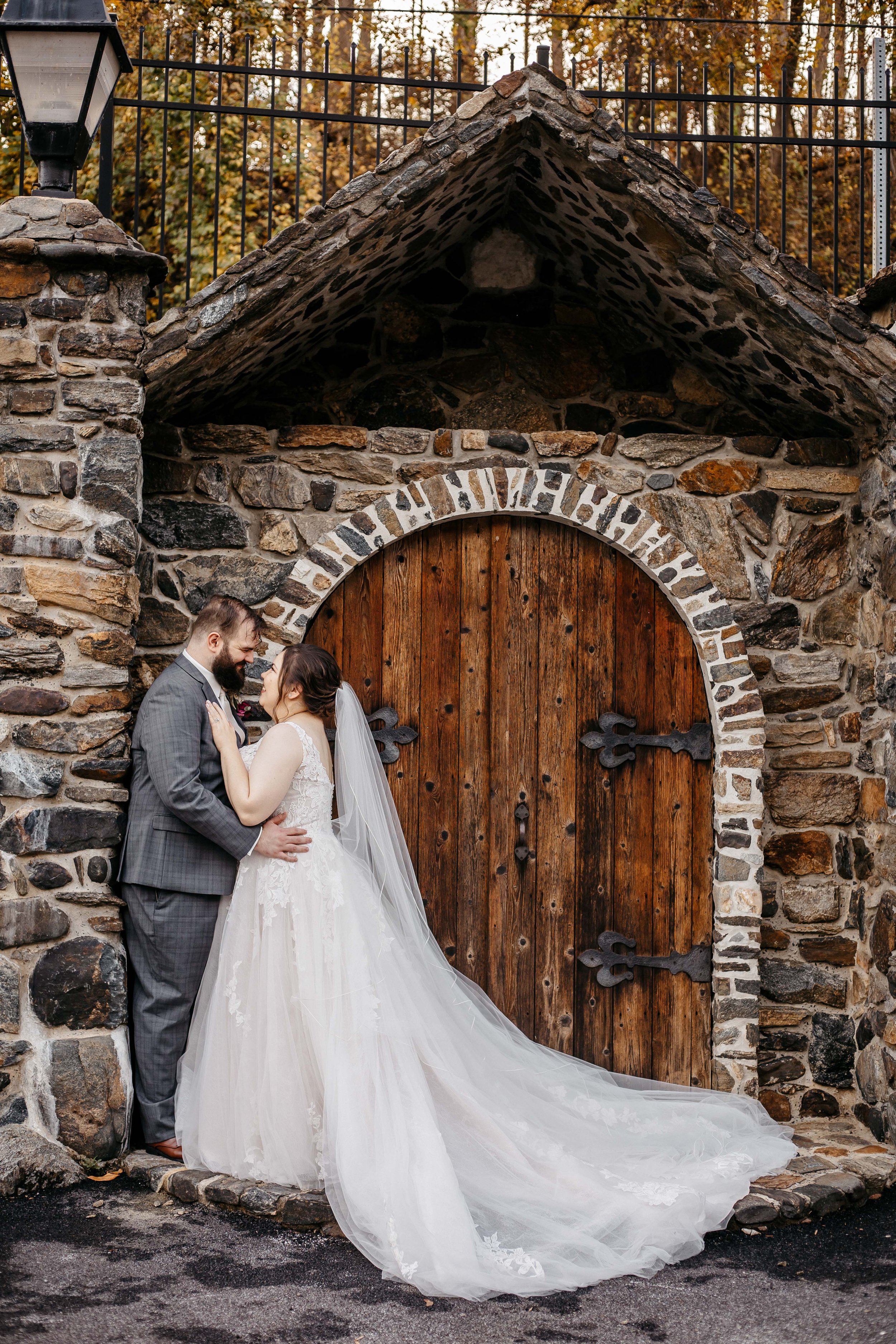 A bride and groom at Kings Mill in front of a big brown double door.