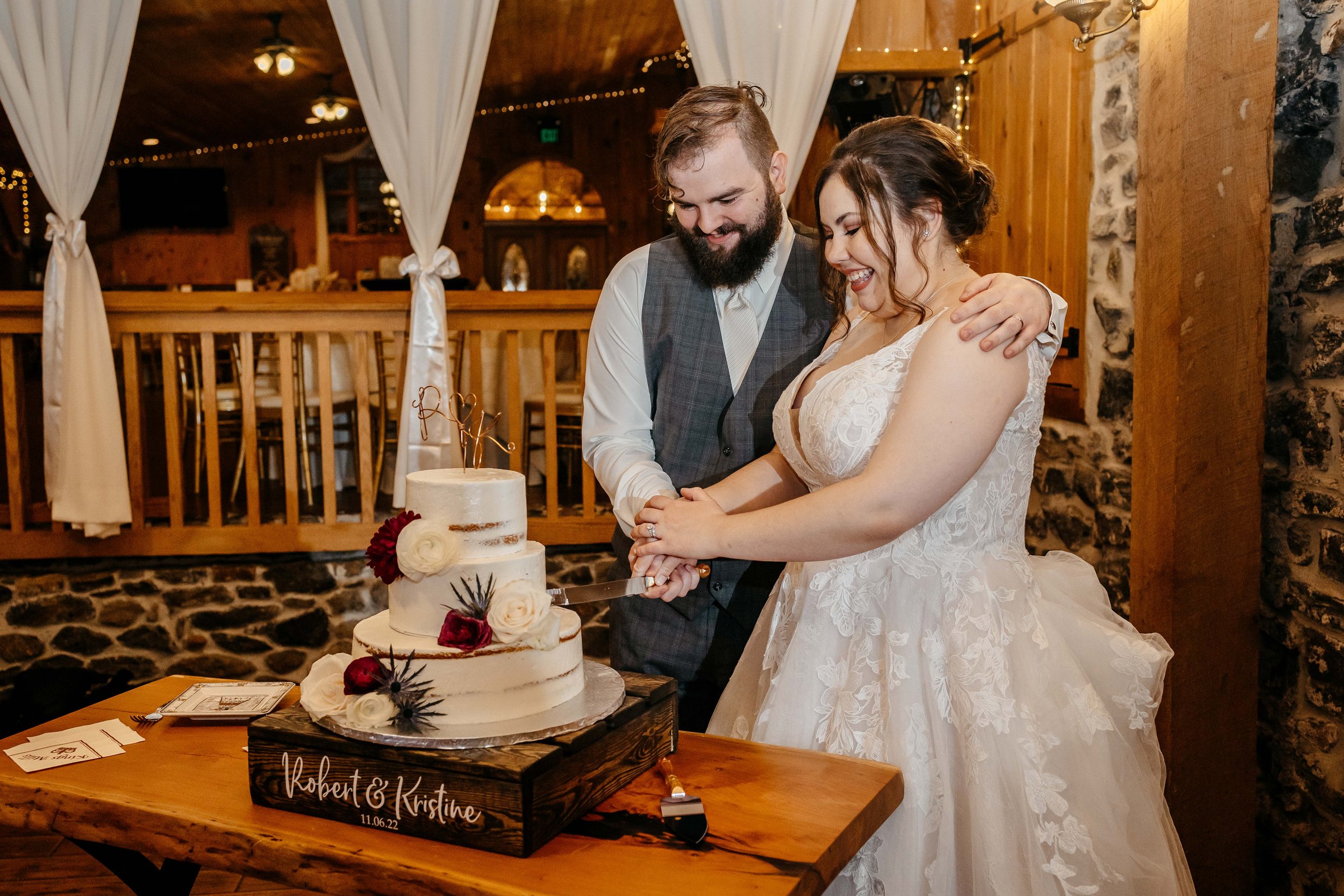 A bride and groom cut the cake together.