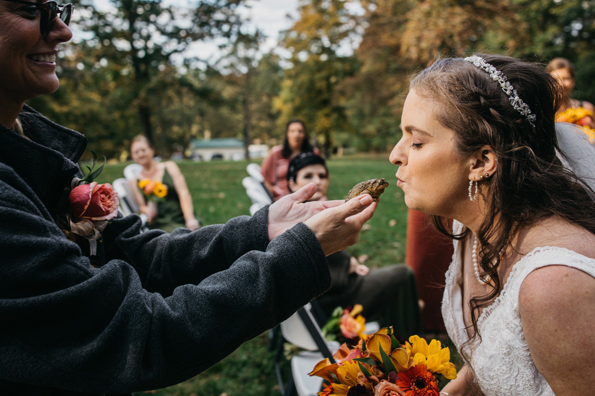 A bride kisses a frog on her wedding day.