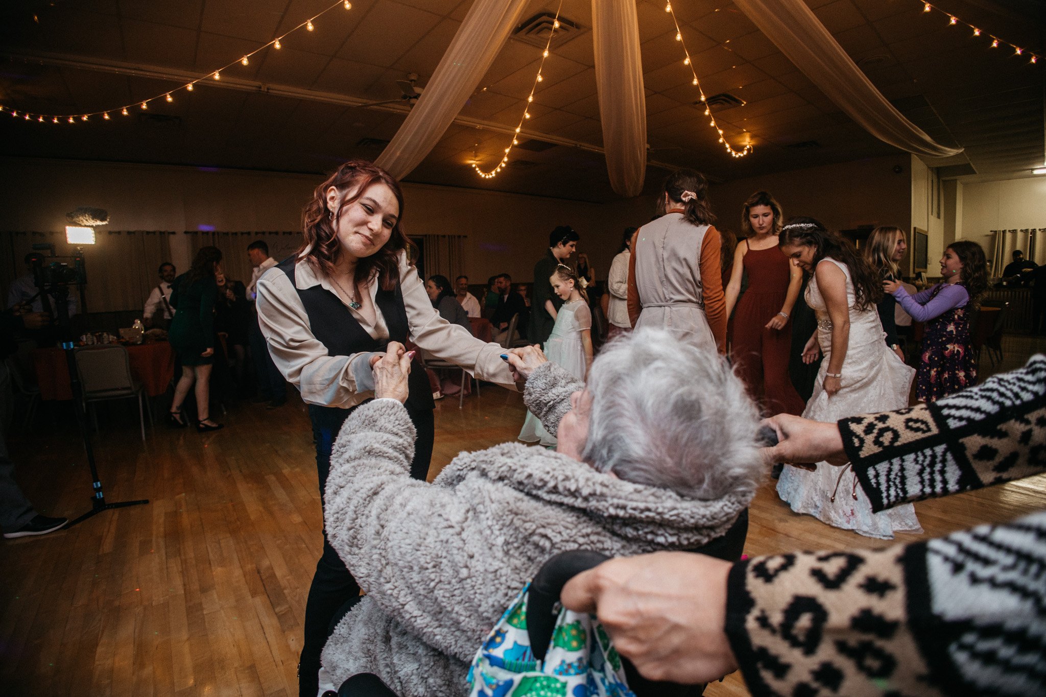 A wedding guest dances with grandma.