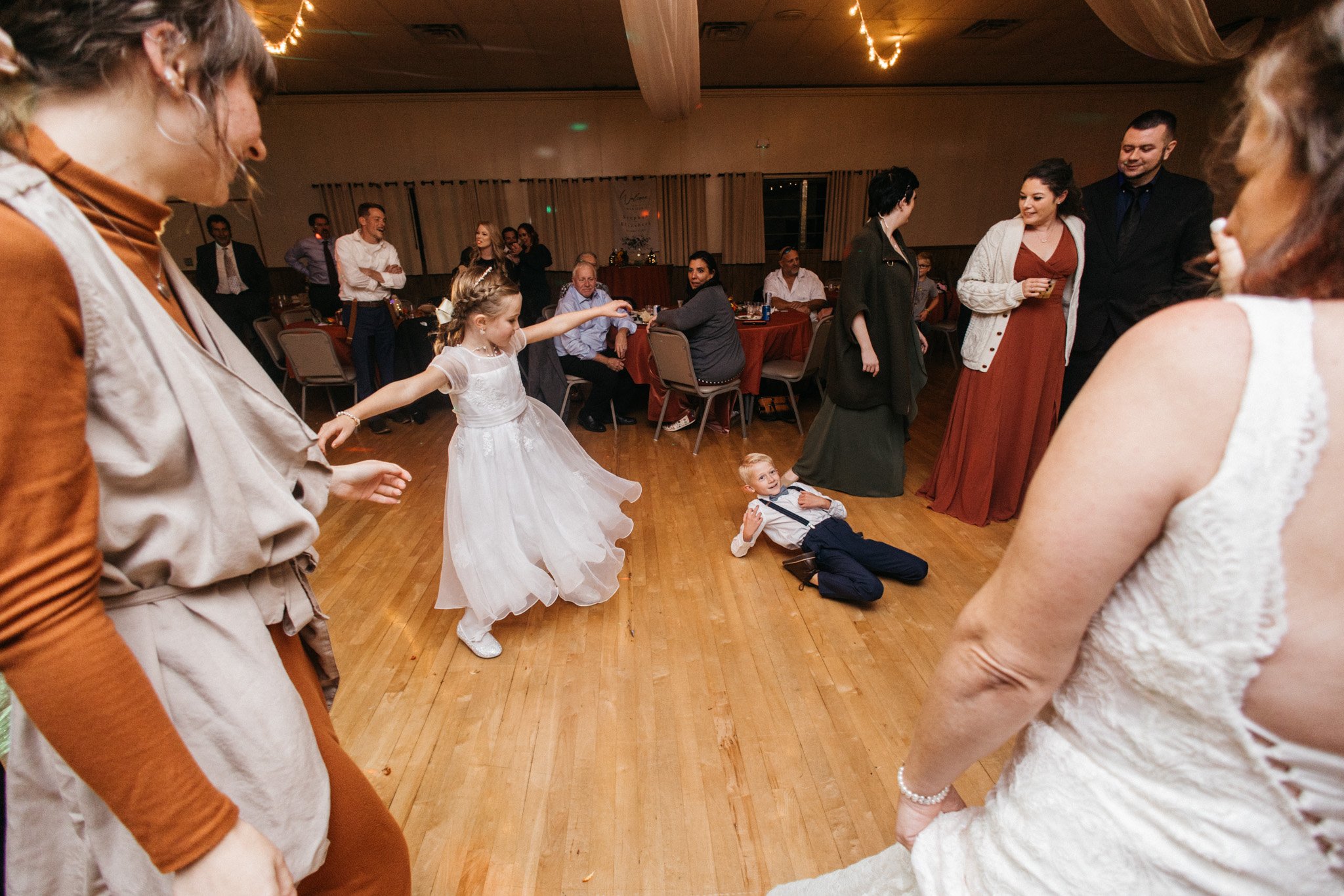 Two kids dance at a reception.