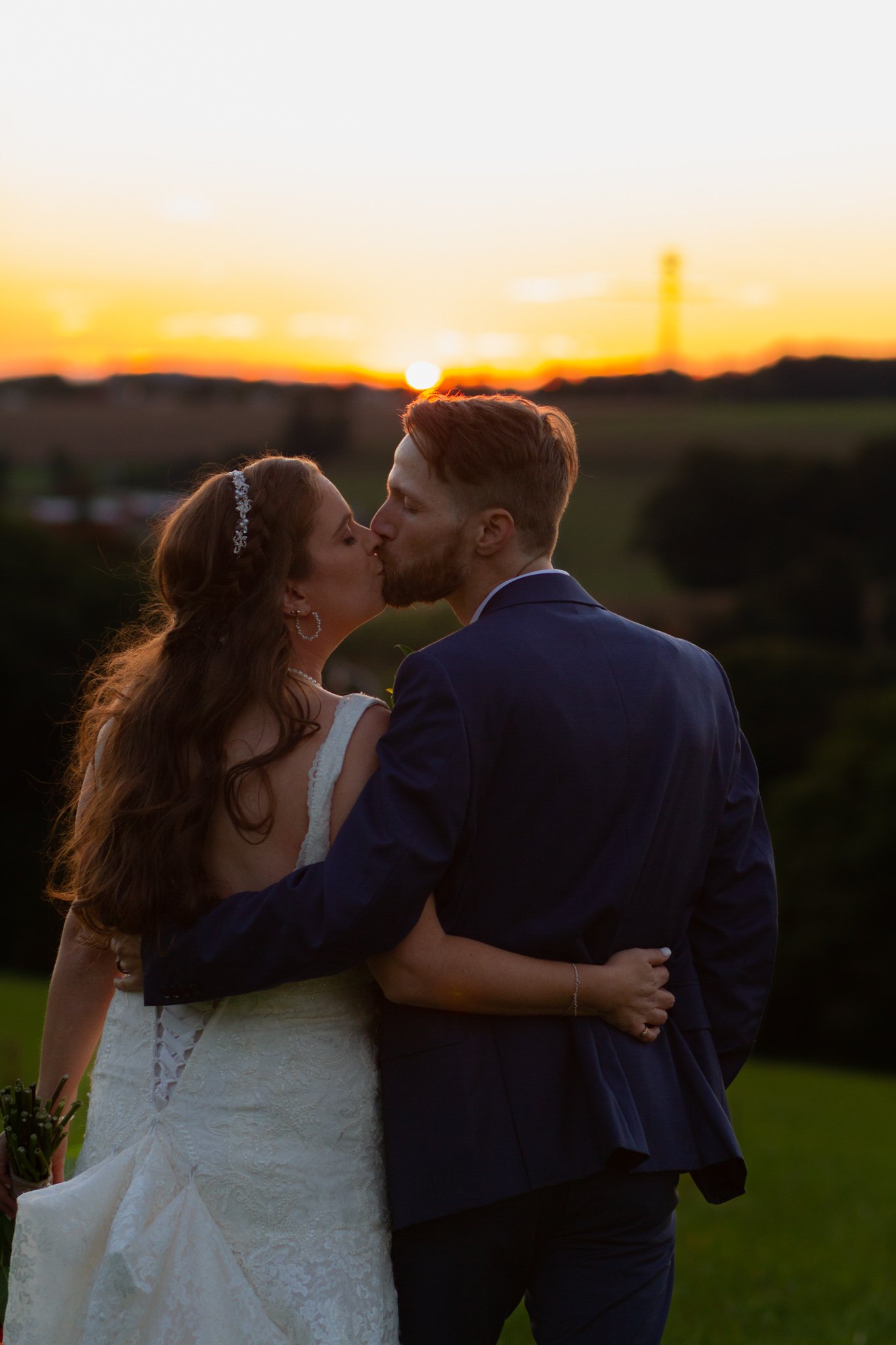 A bride and groom kiss at sunset at Fireside at the Fiddlers.