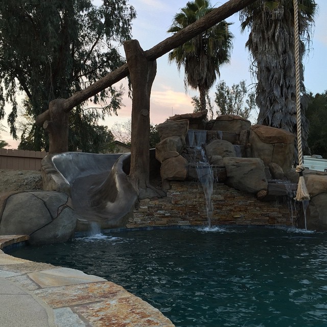 Artificial rock slide and log swing. Quartzite flagstone, with pebbletec.