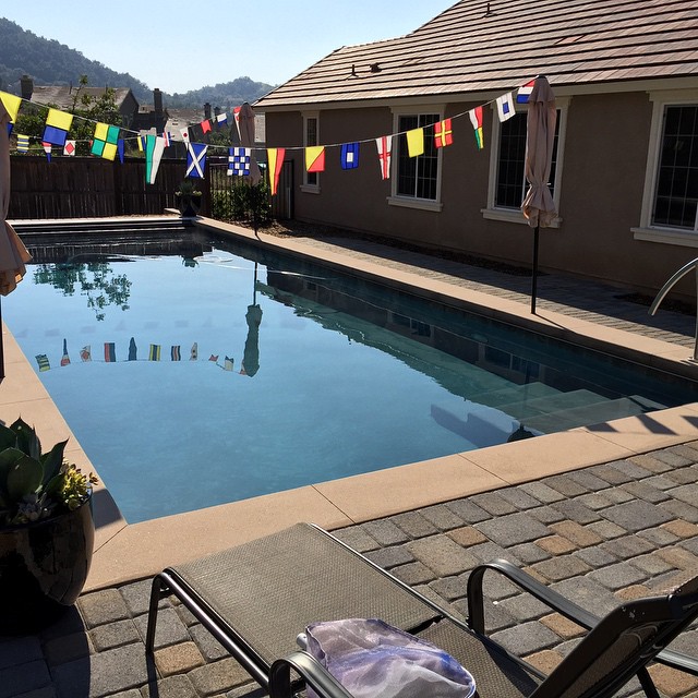 Rectangular pool with auto cover. Cantilever pool coping with gray plaster.