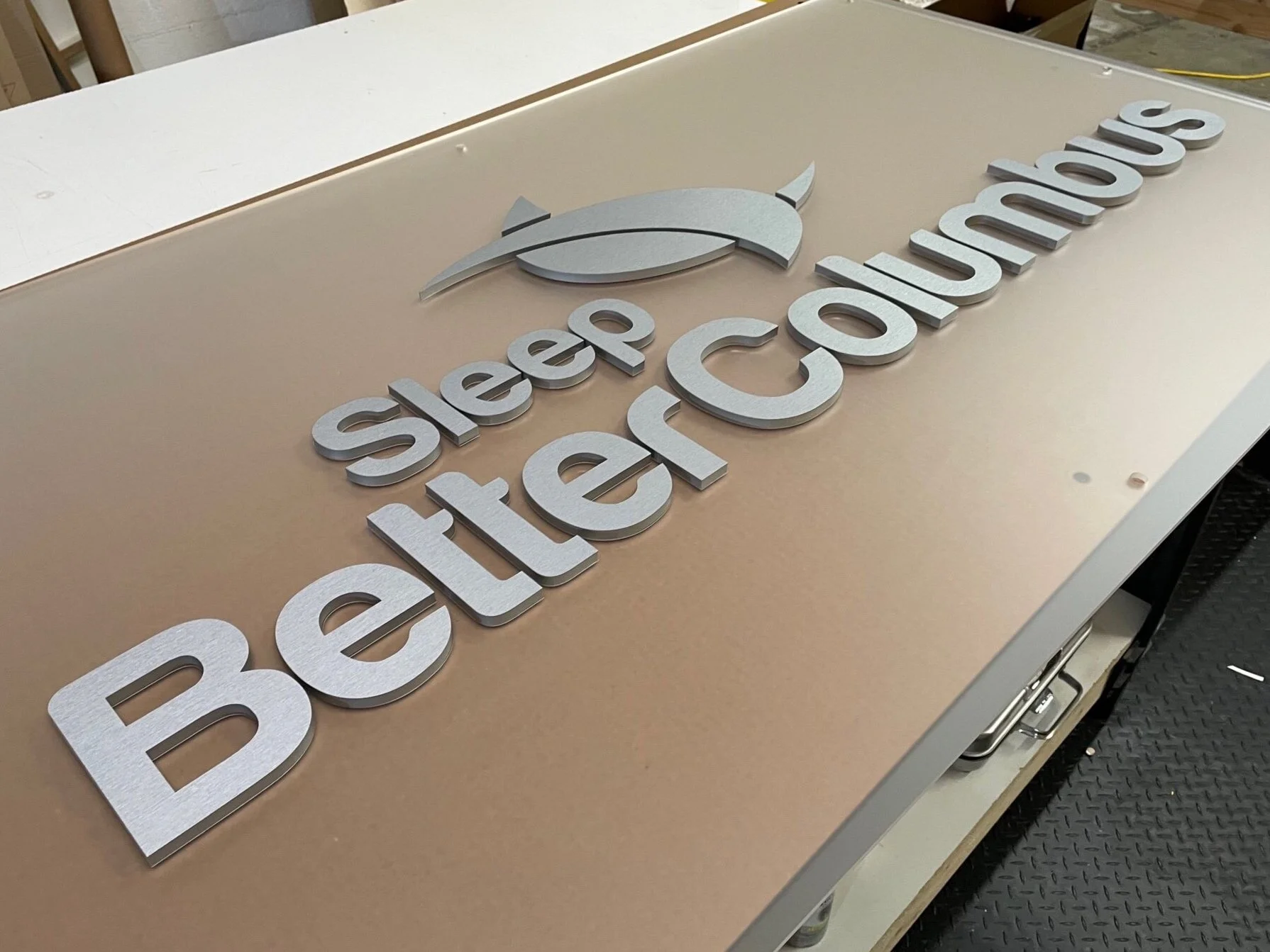 Laser cut sign on a frosted backer and brushed aluminum finished letters