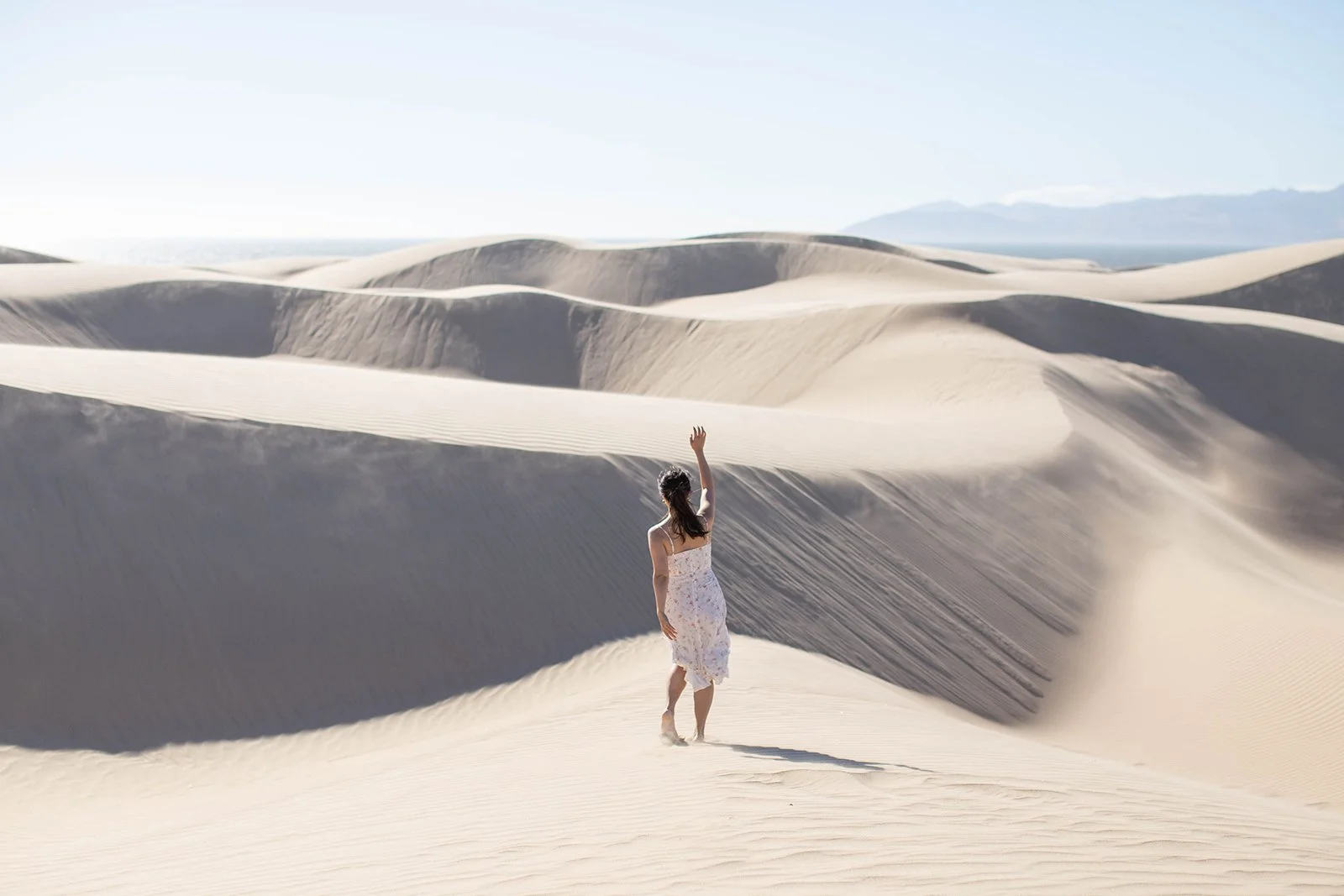 Sophia waving at the sand dunes