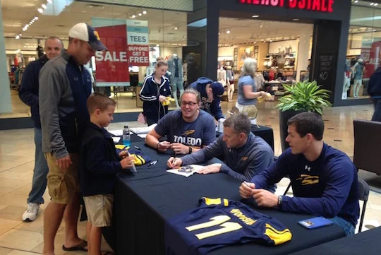 UT Football Coach Jason Candle, center, signed an autograph for a fan last month as senior offensive lineman Storm Norton, left, and junior quarterback Logan Woodside watched at the first event of the Rocket Summer Liftoff Series.