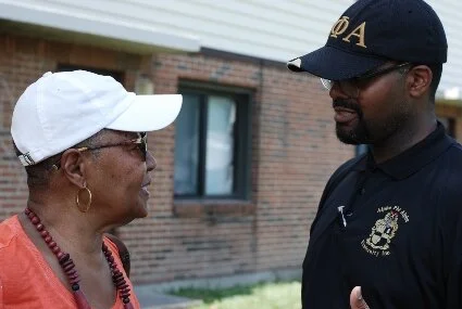 Books 4 Buddies Founder and President Laneta Goings, left, speaks with Alpha Phi Alpha Inc. Alpha Xi Lambda Chapter Vice President John C. Jones, right.